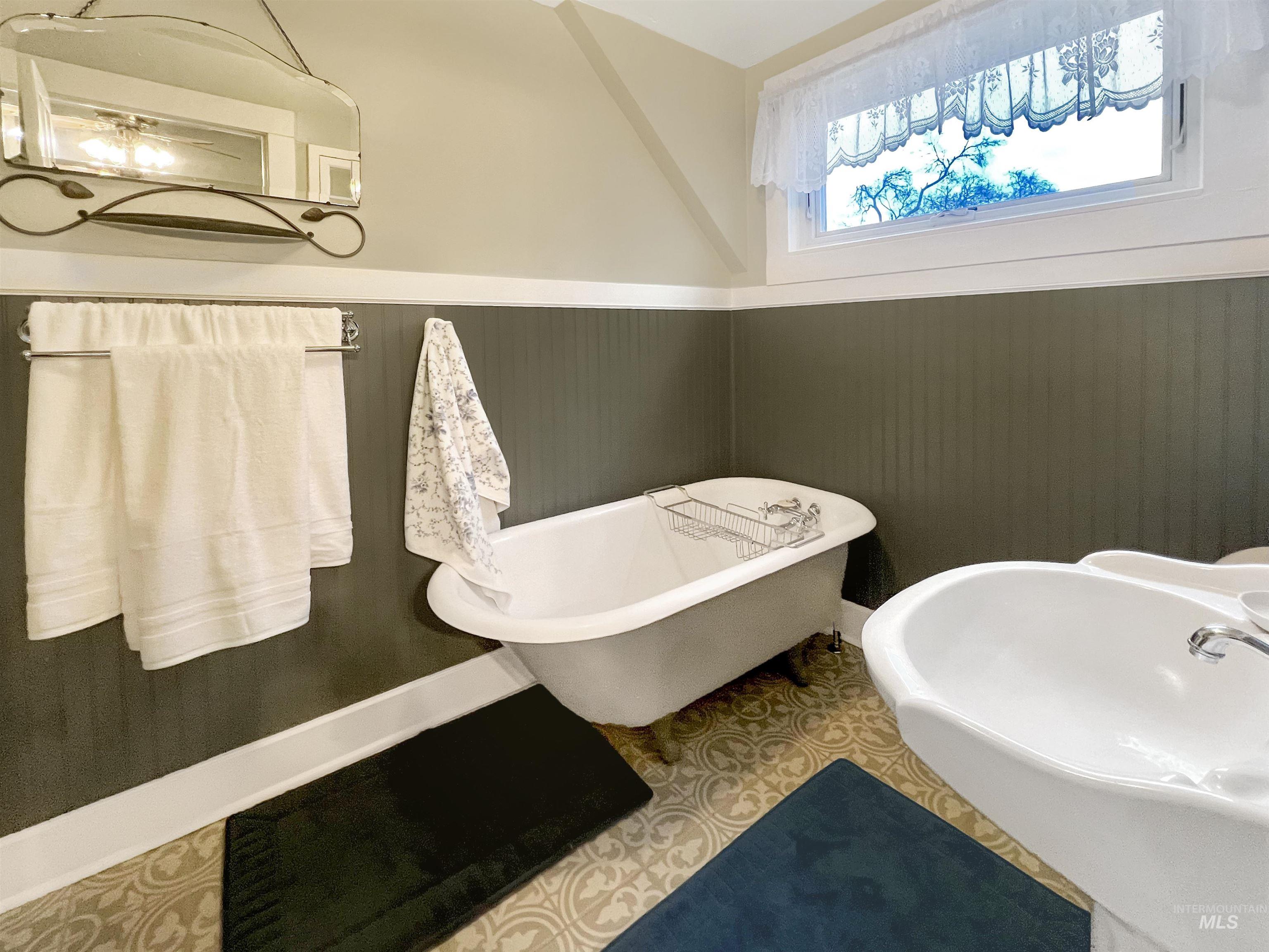 Full bath with wainscoting, a soaking tub.