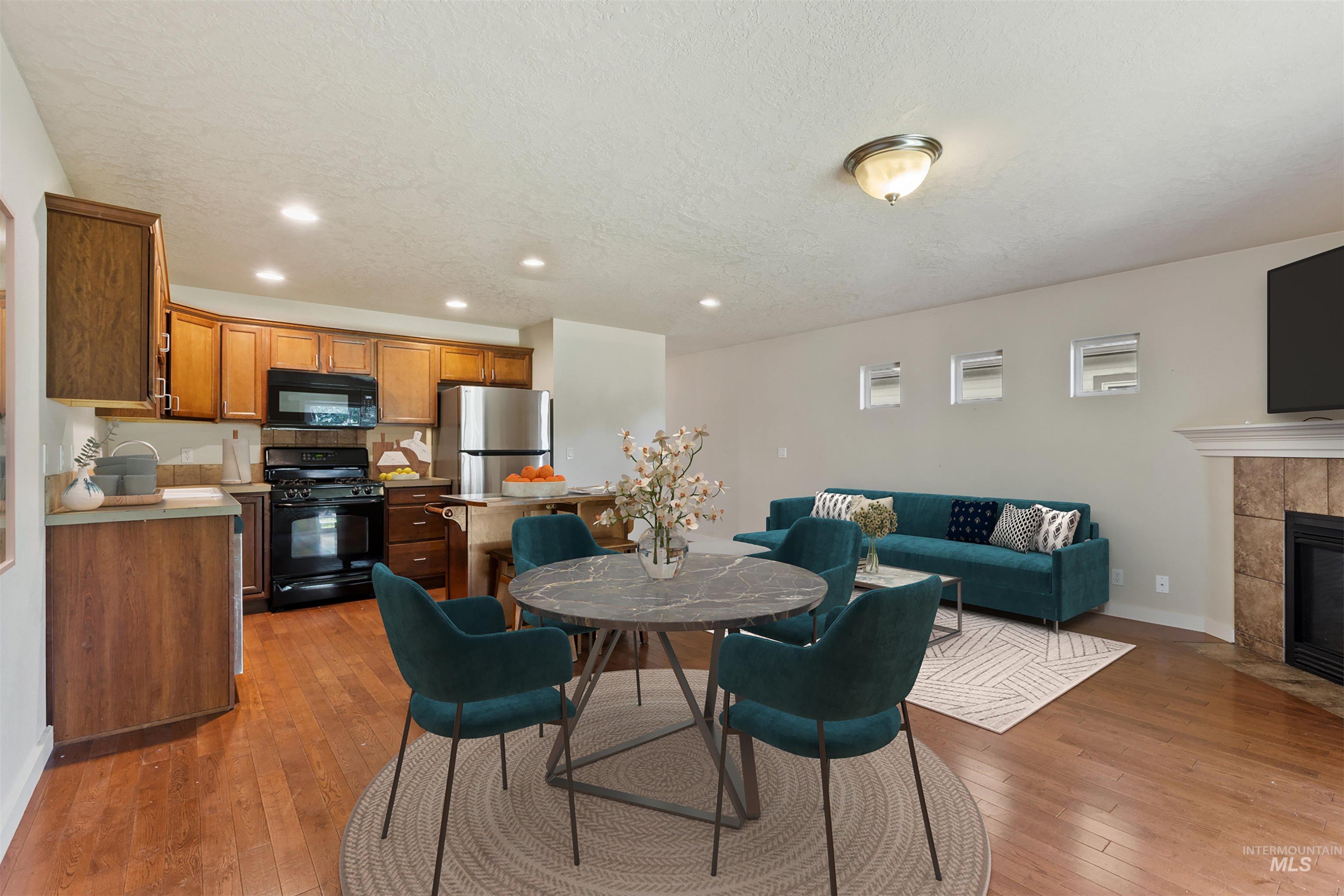 Dining room featuring recessed lighting, light wood finished floors, a fireplace, and a textured ceiling