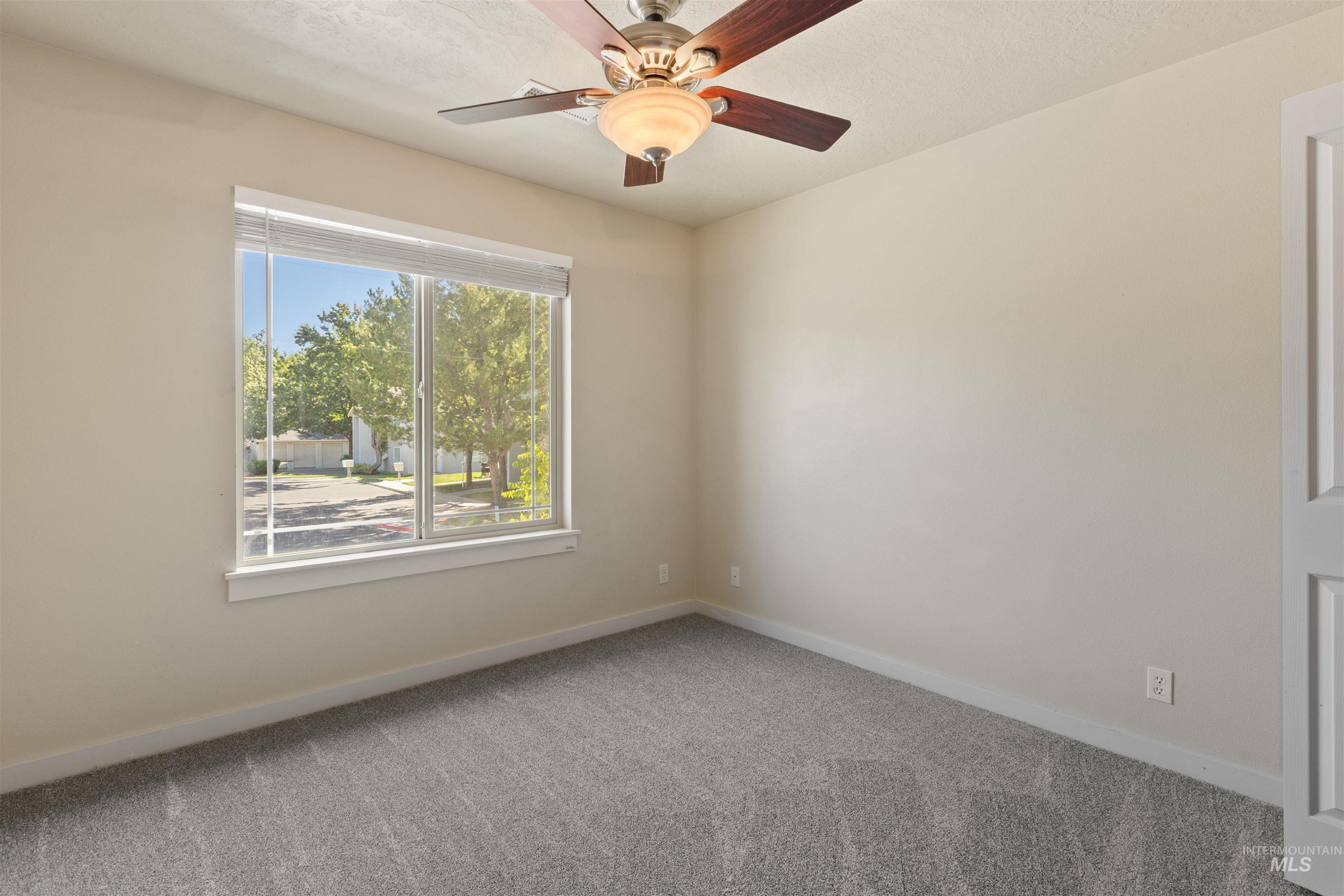 Unfurnished room featuring carpet floors and a ceiling fan
