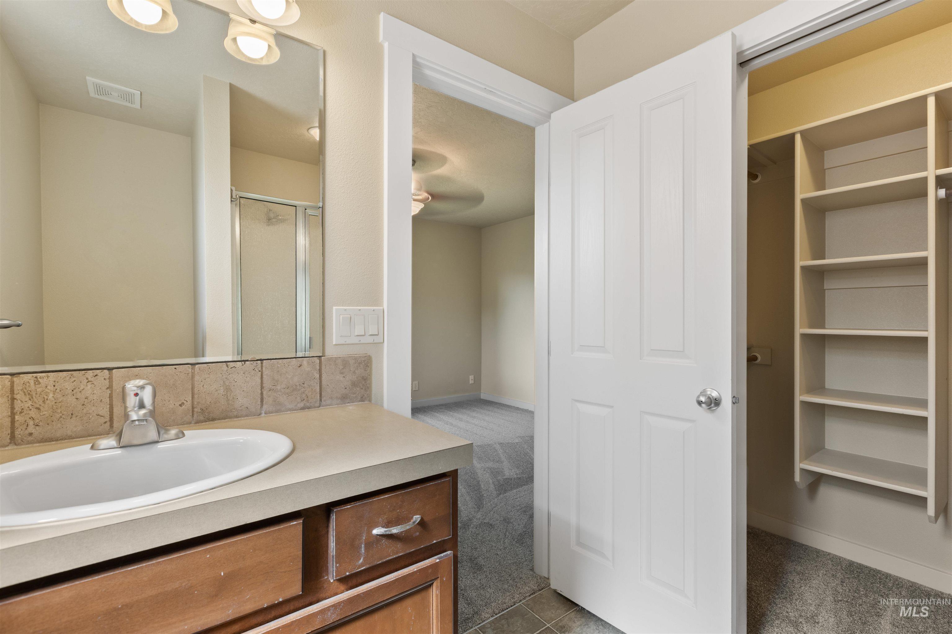Bathroom with a stall shower, vanity, and light tile patterned floors