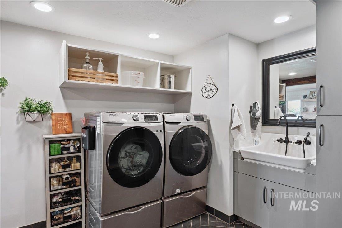 Laundry room featuring independent washer and dryer, recessed lighting, and dark tile patterned floors