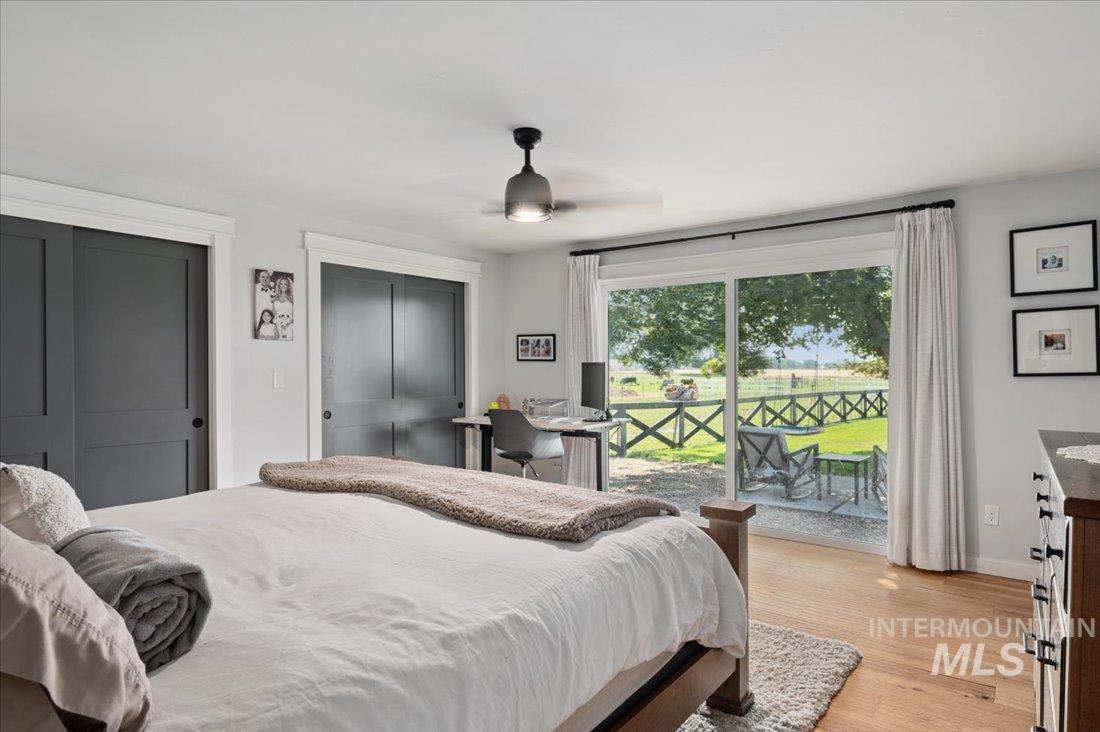 Bedroom with two closets, access to outside, and light wood-style flooring