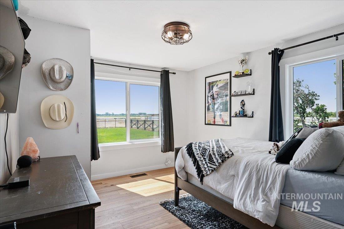 Bedroom featuring light wood-style flooring and multiple windows
