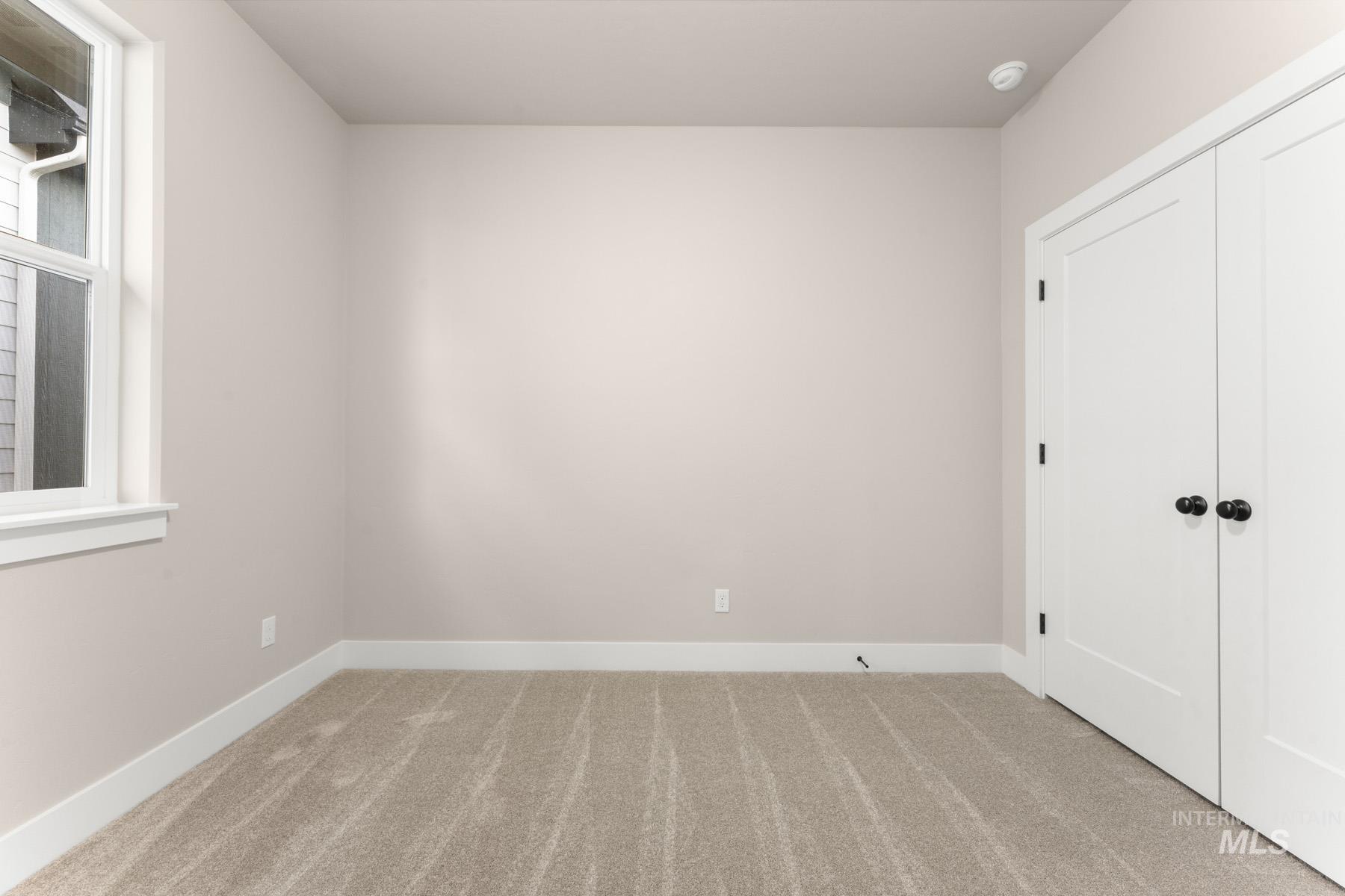 Unfurnished bedroom with light colored carpet and a closet