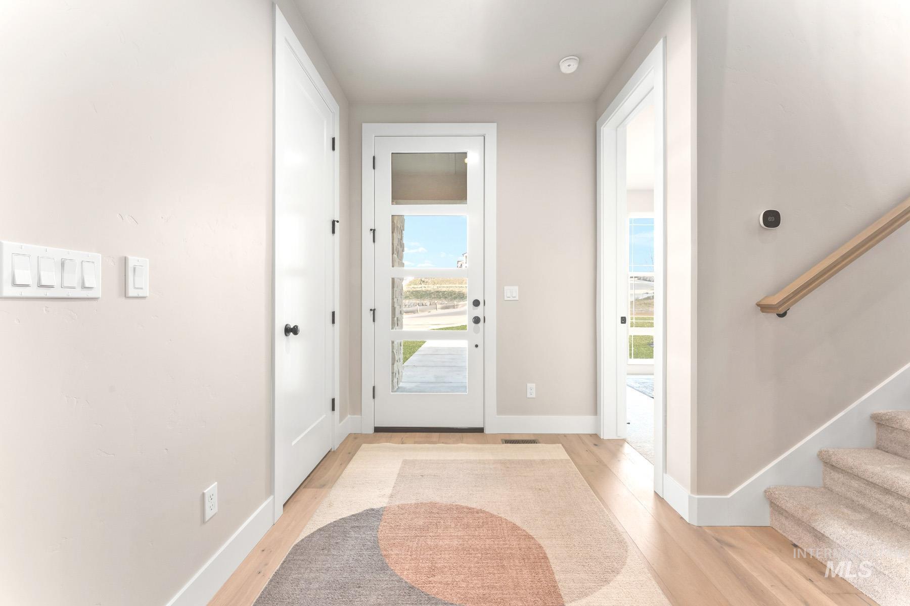 Entrance foyer featuring stairway and light wood-style flooring