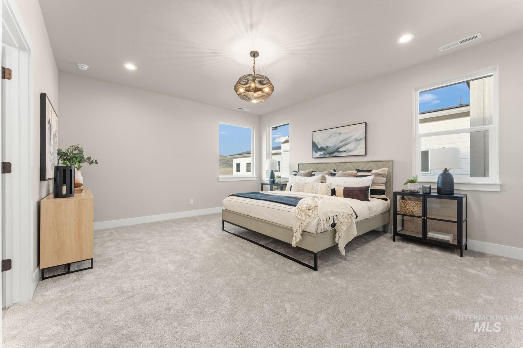 Bedroom featuring light carpet and hanging lights