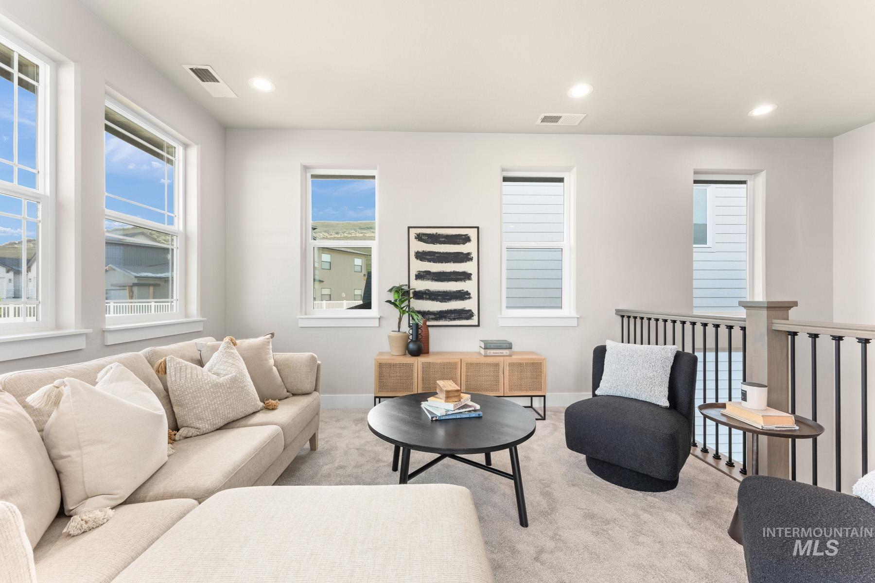 Carpeted living area with recessed lighting and baseboards