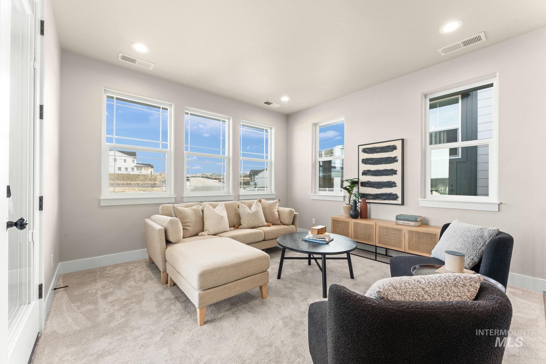 Living room with light colored carpet and recessed lighting