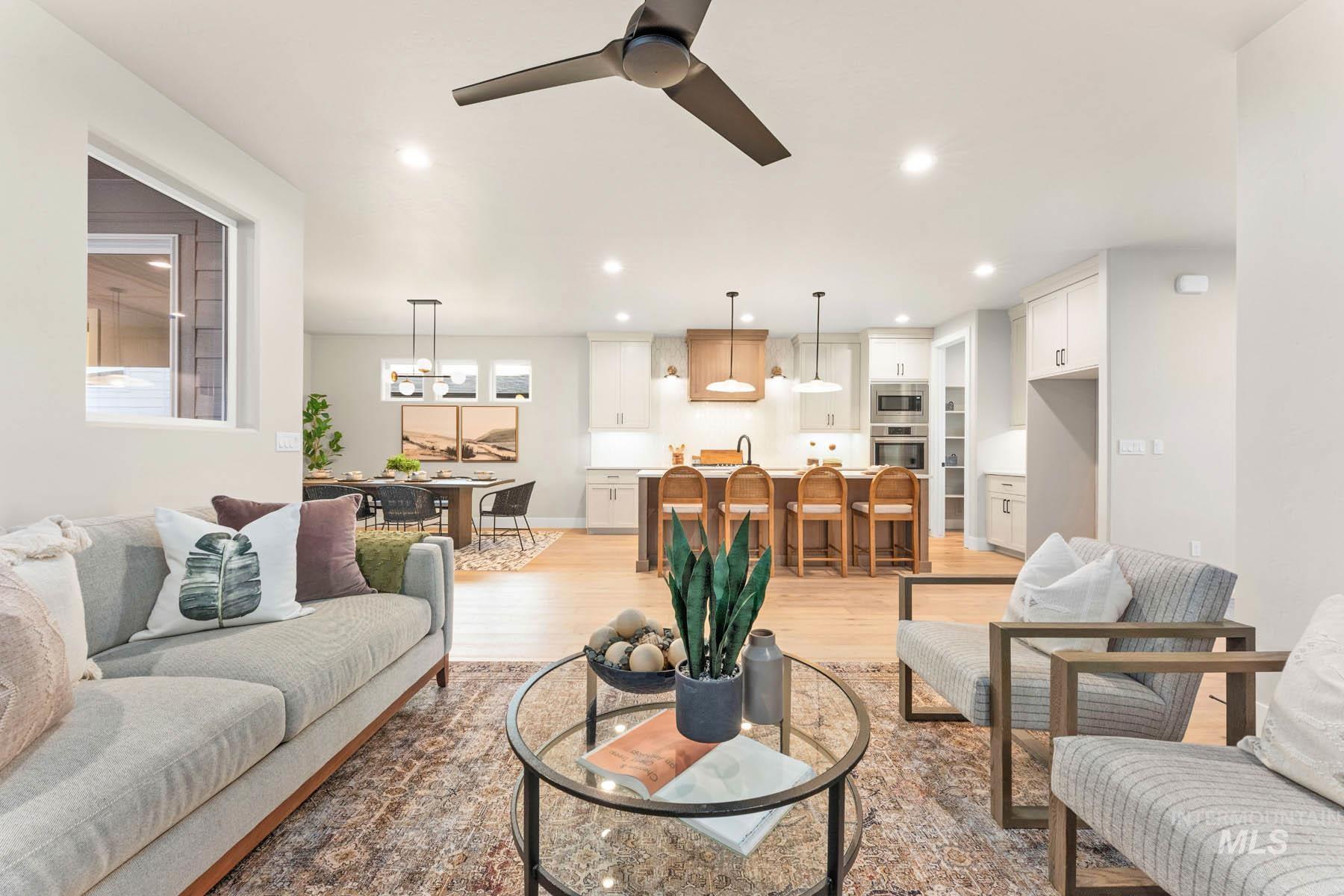Living room with a ceiling fan, light wood finished floors, and recessed lighting