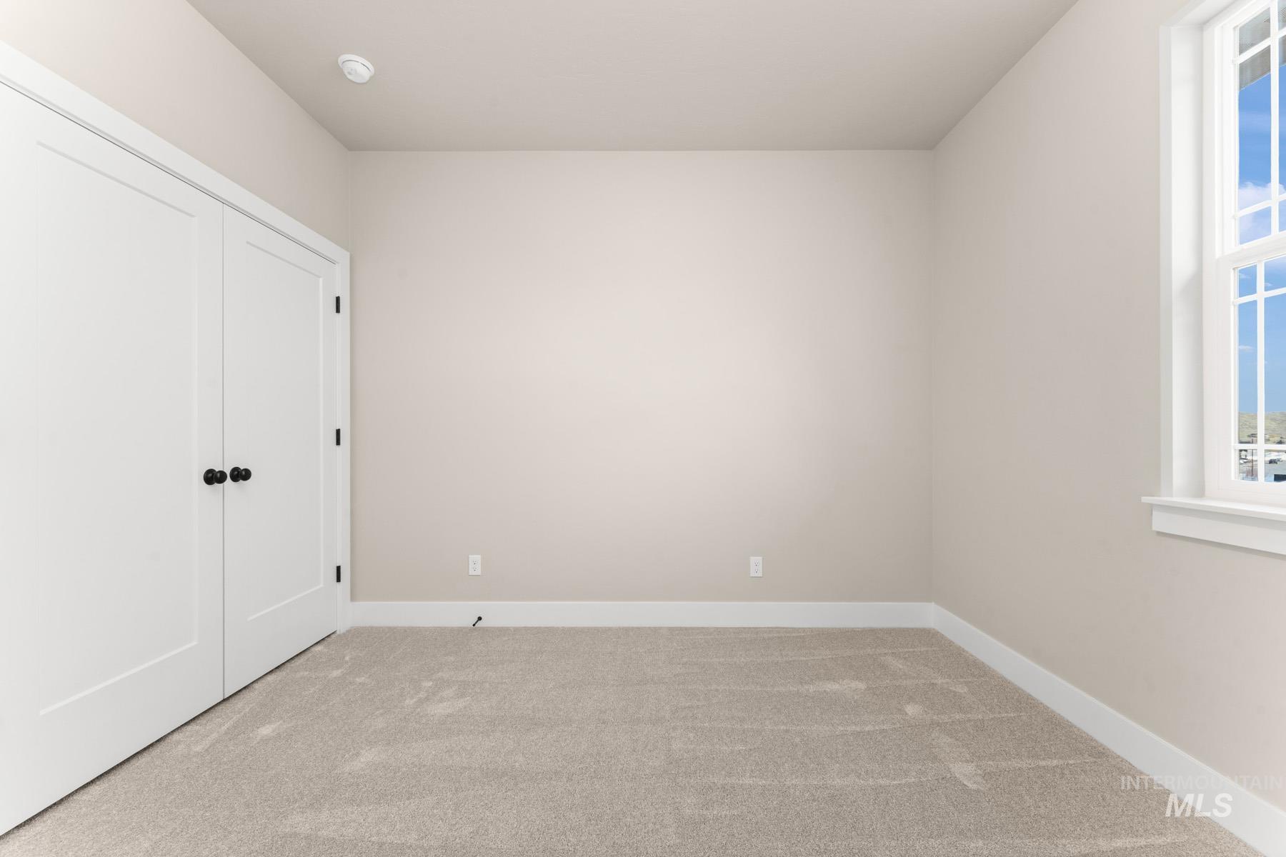 Unfurnished bedroom featuring light carpet and a closet