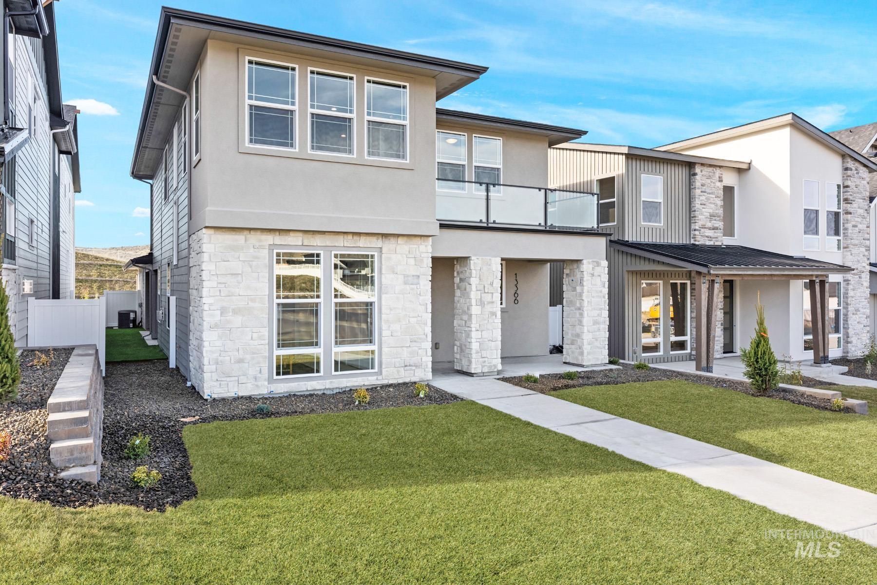 Contemporary home with stucco siding, stone siding, and a balcony