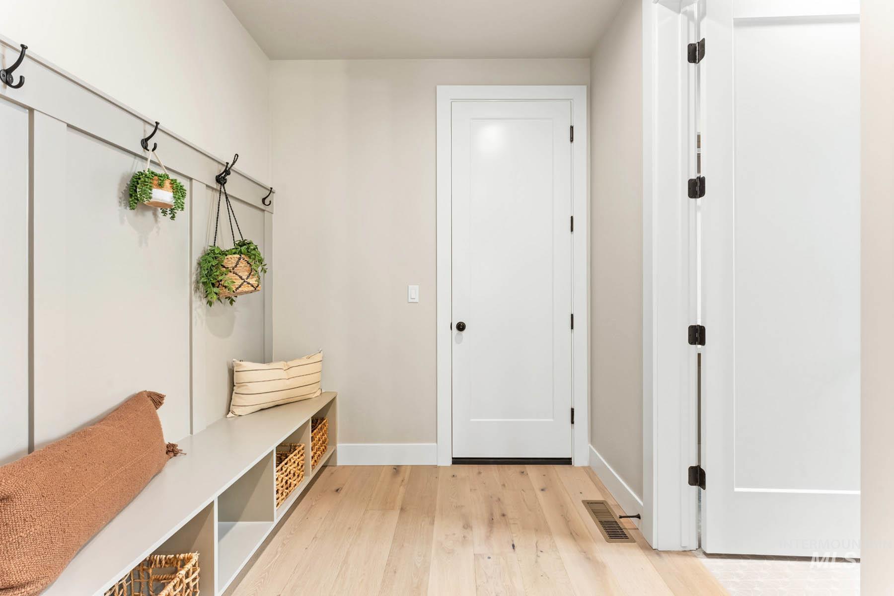 Mudroom featuring light wood finished floors and baseboards