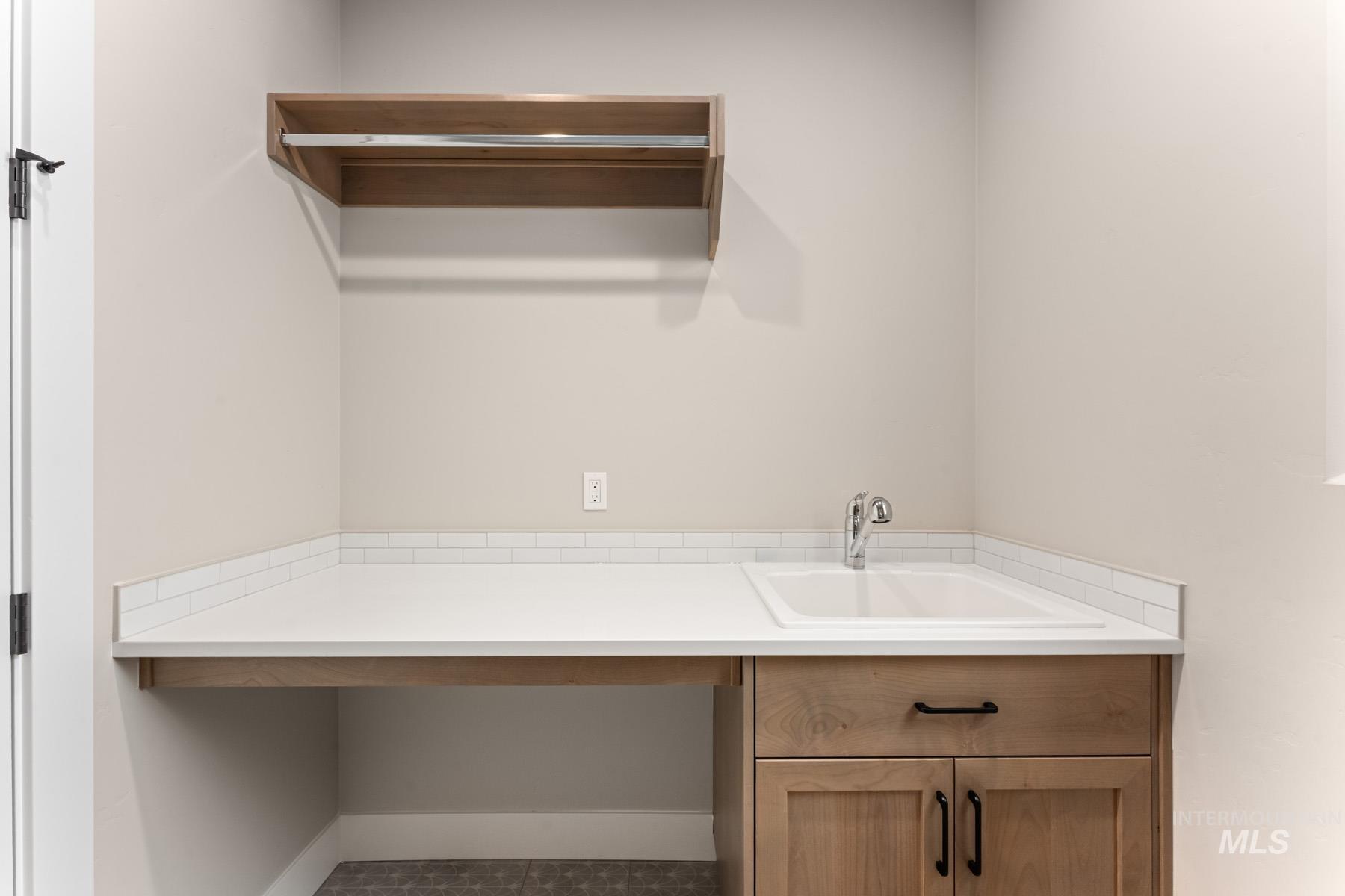 Laundry room featuring a sink and baseboards