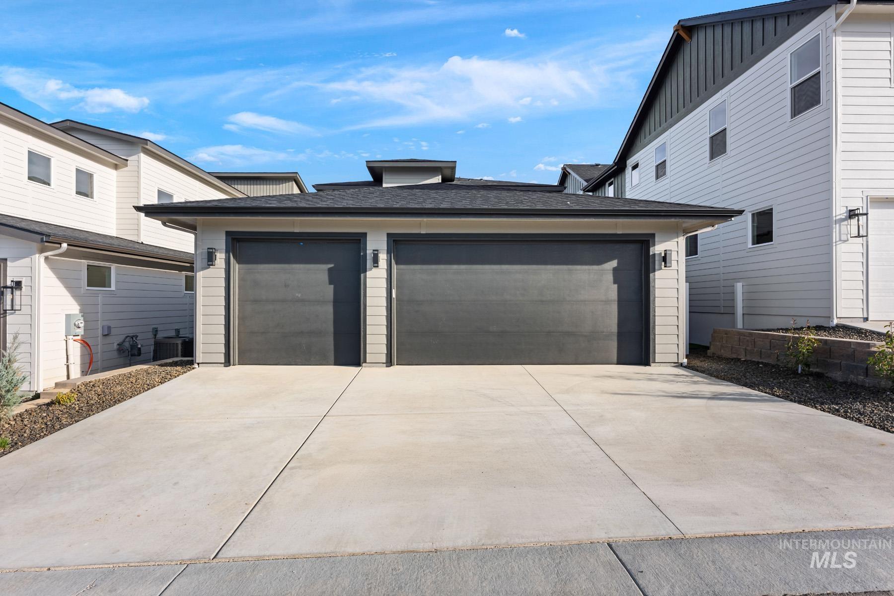 View of front of home with a shingled roof and driveway