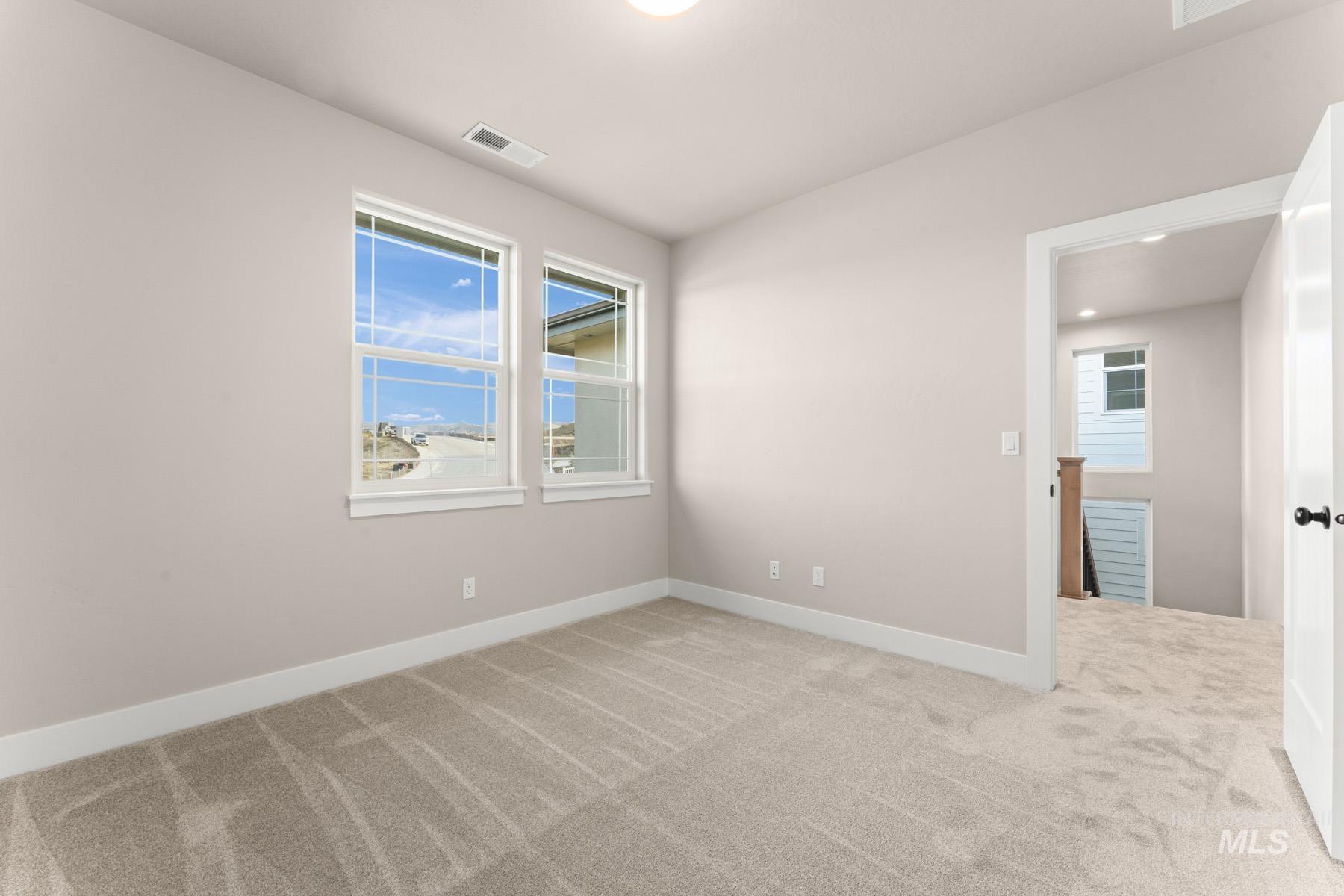 Unfurnished room featuring light colored carpet and baseboards