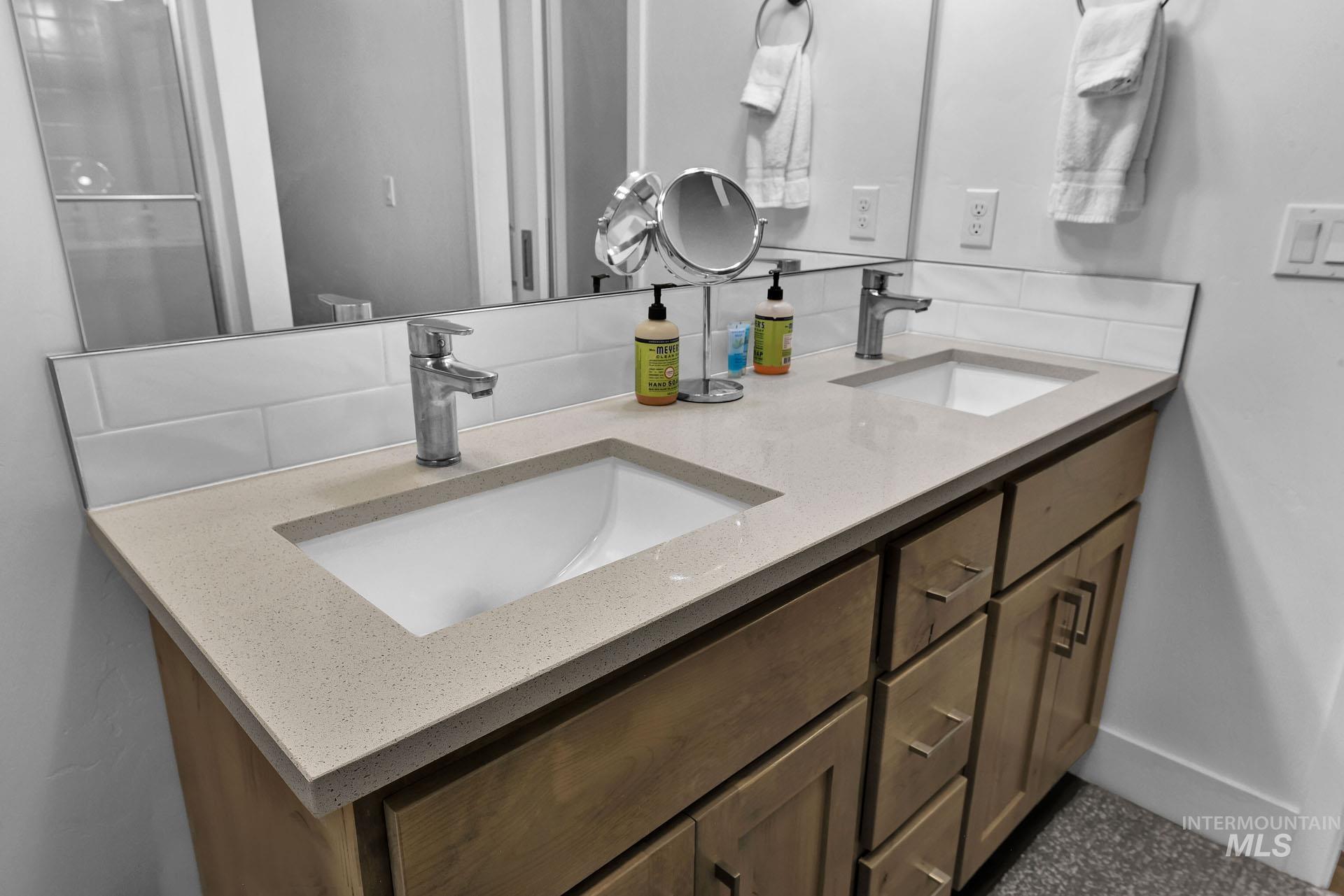 Bathroom with double vanity and baseboards