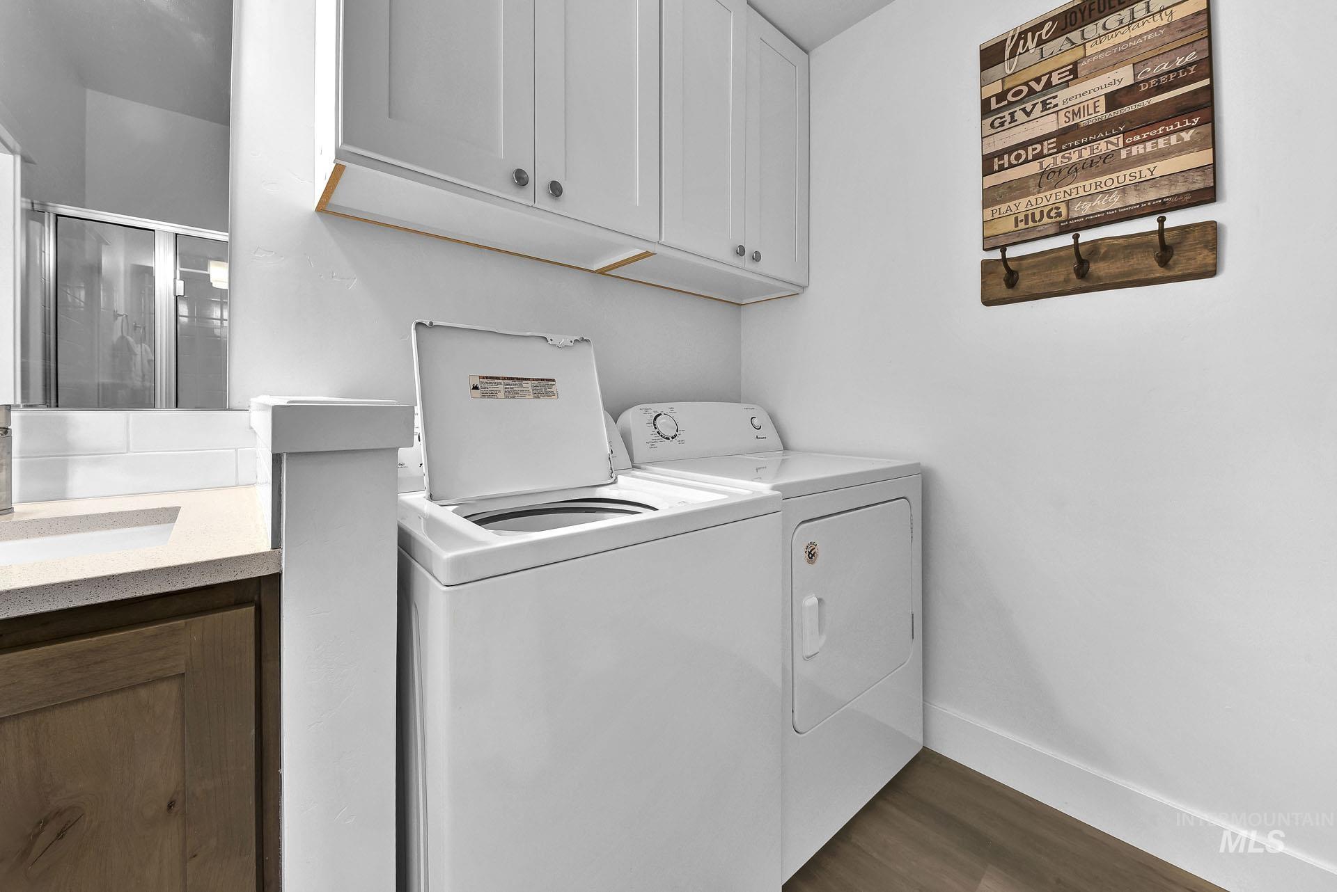 Laundry area featuring dark wood finished floors and washer and dryer