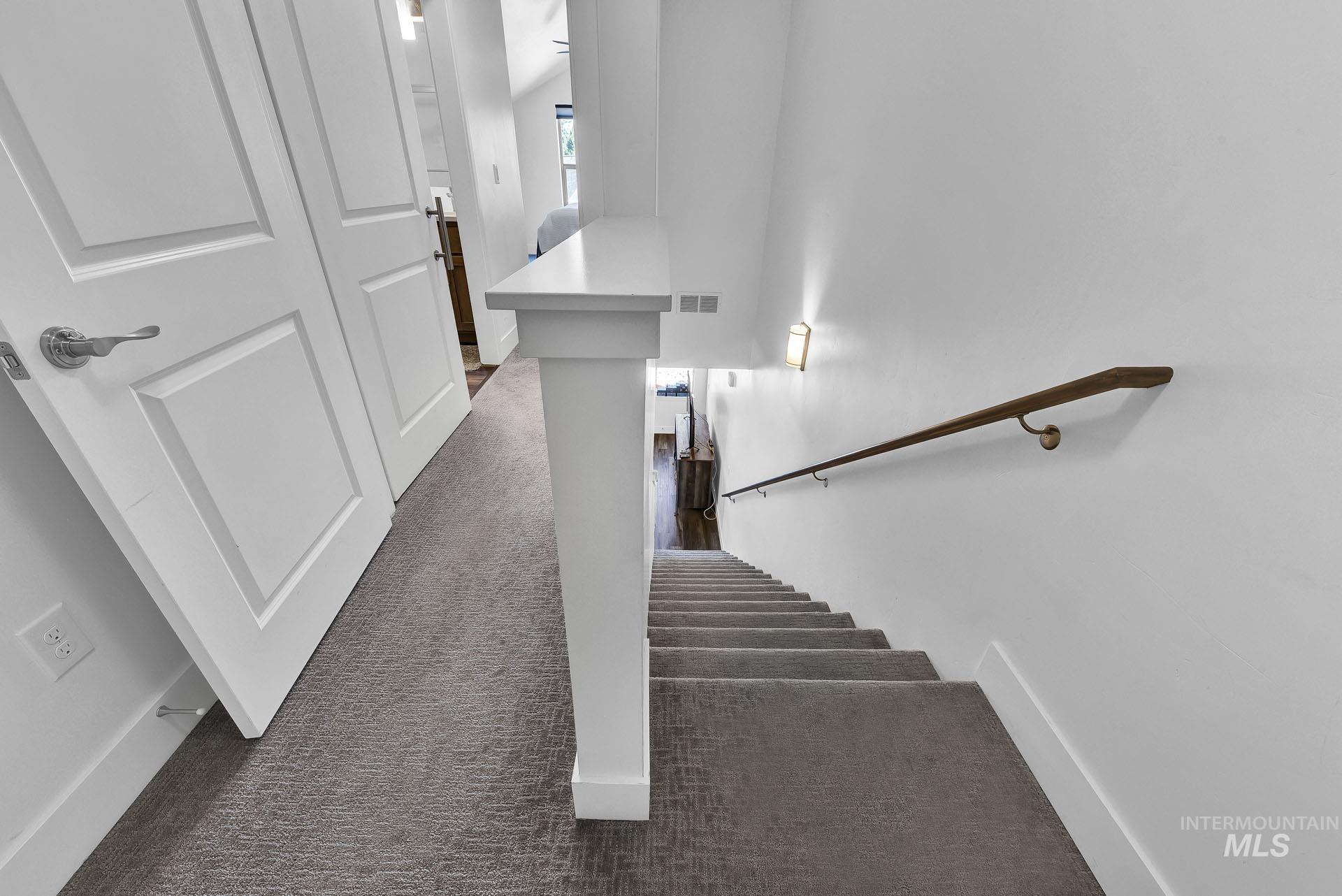 Stairway with carpet flooring and baseboards