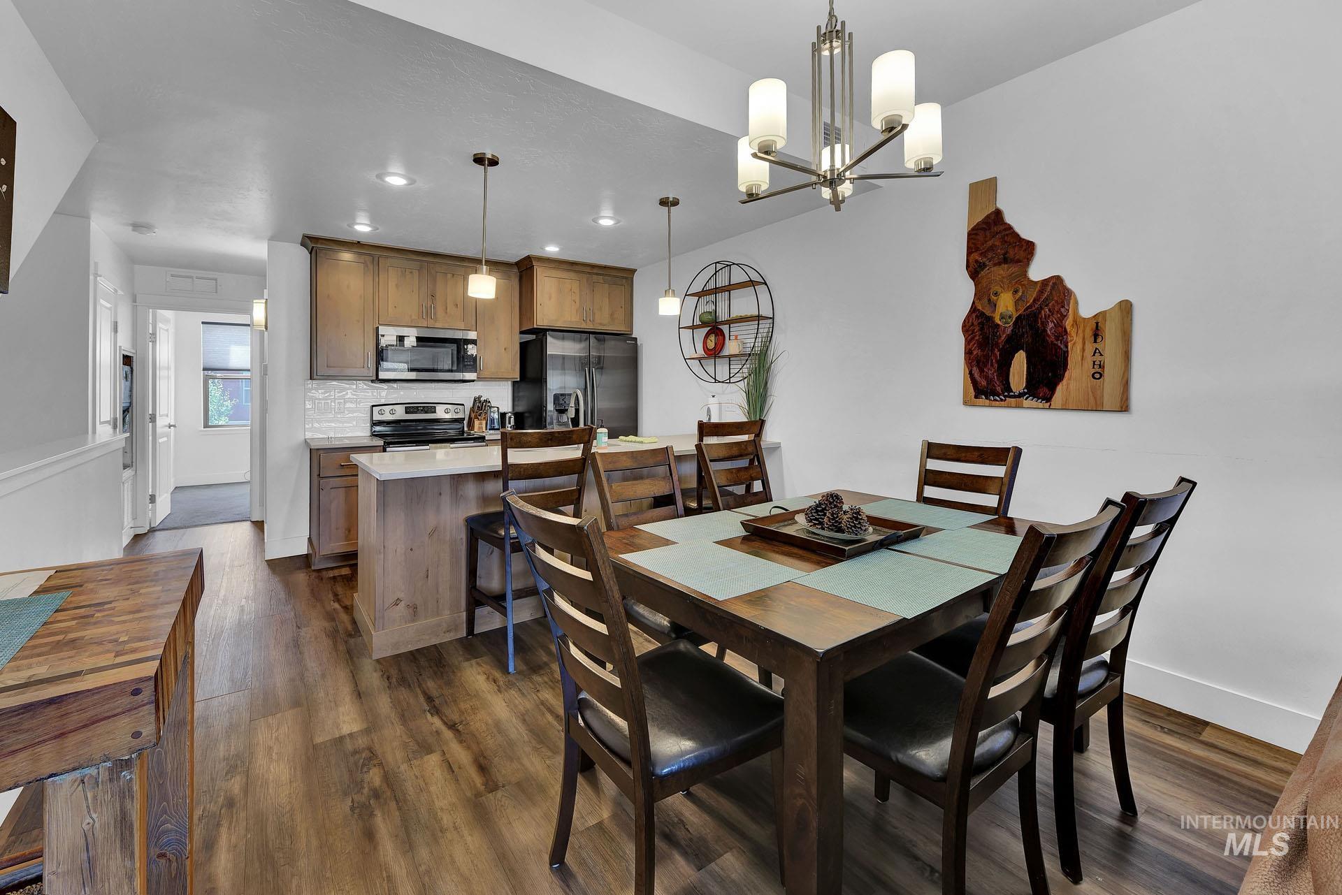Dining room featuring dark wood-style floors and suspended lighting