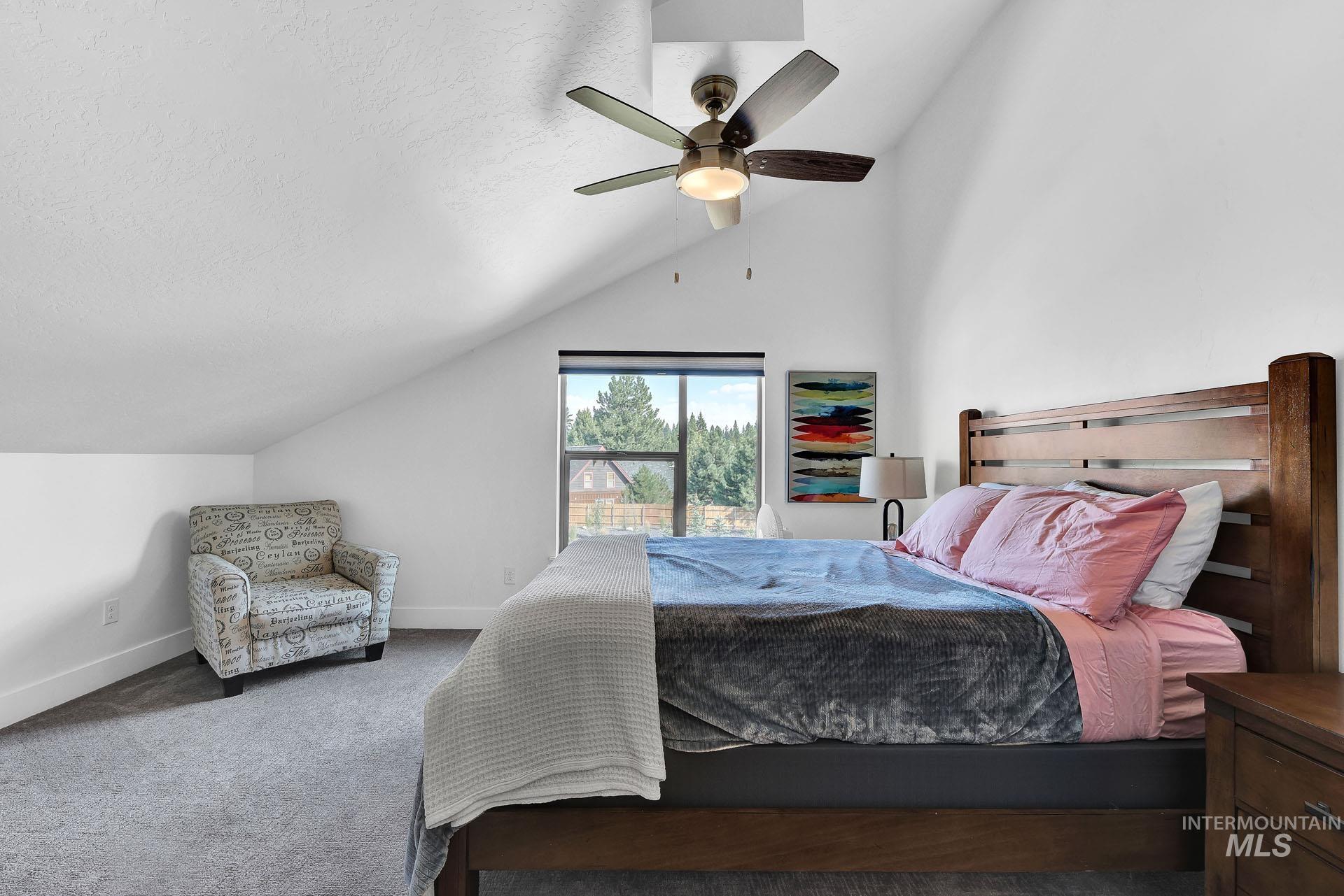 Carpeted bedroom featuring baseboards and a ceiling fan