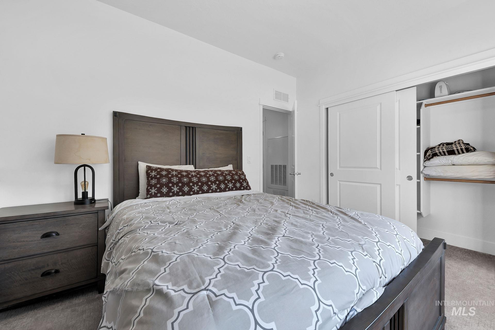 Bedroom featuring dark colored carpet and a closet
