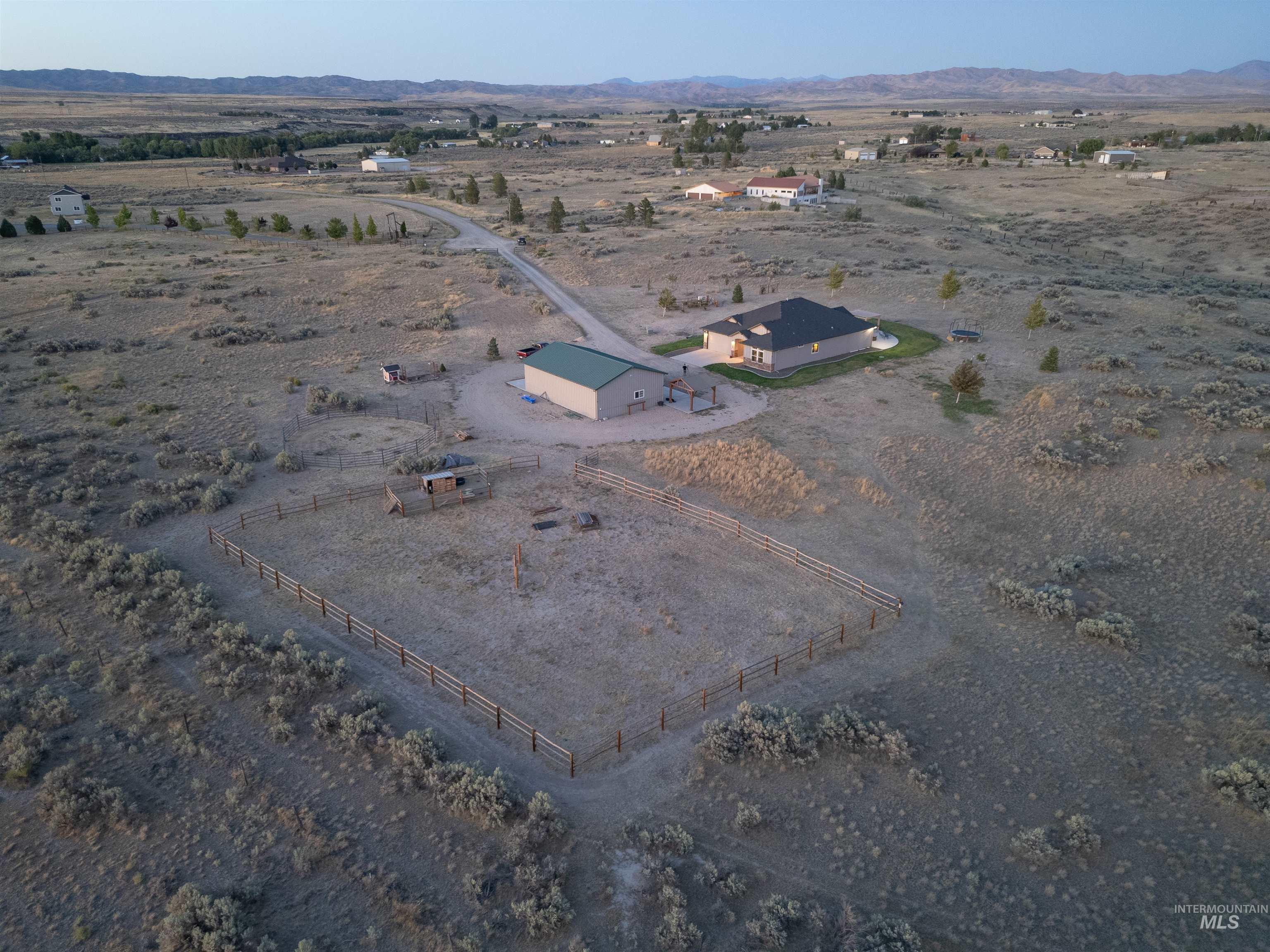 Aerial overview of property's location with rural landscape and a mountainous background
