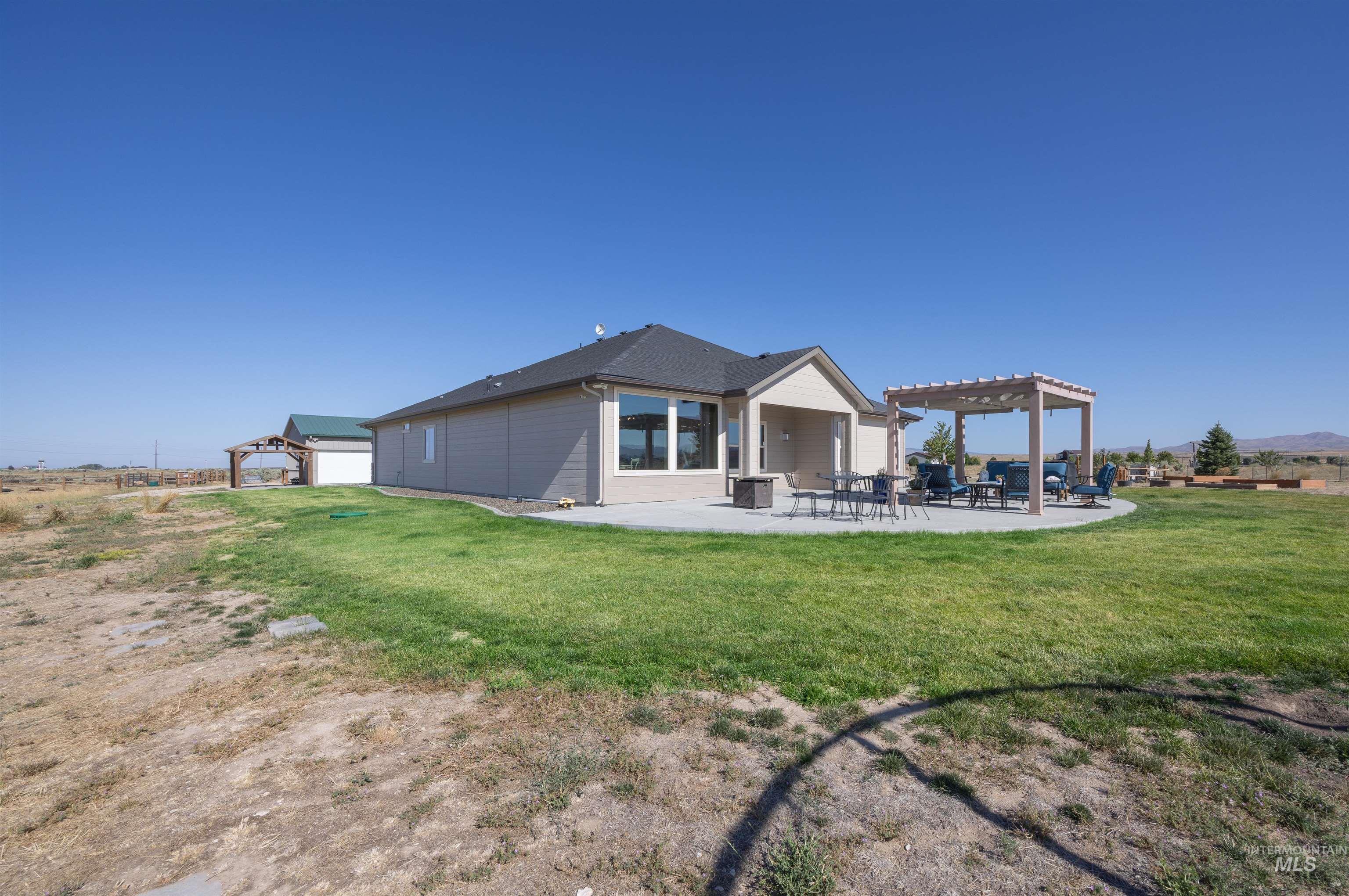 Rear view of house with a patio, a yard, and a pergola