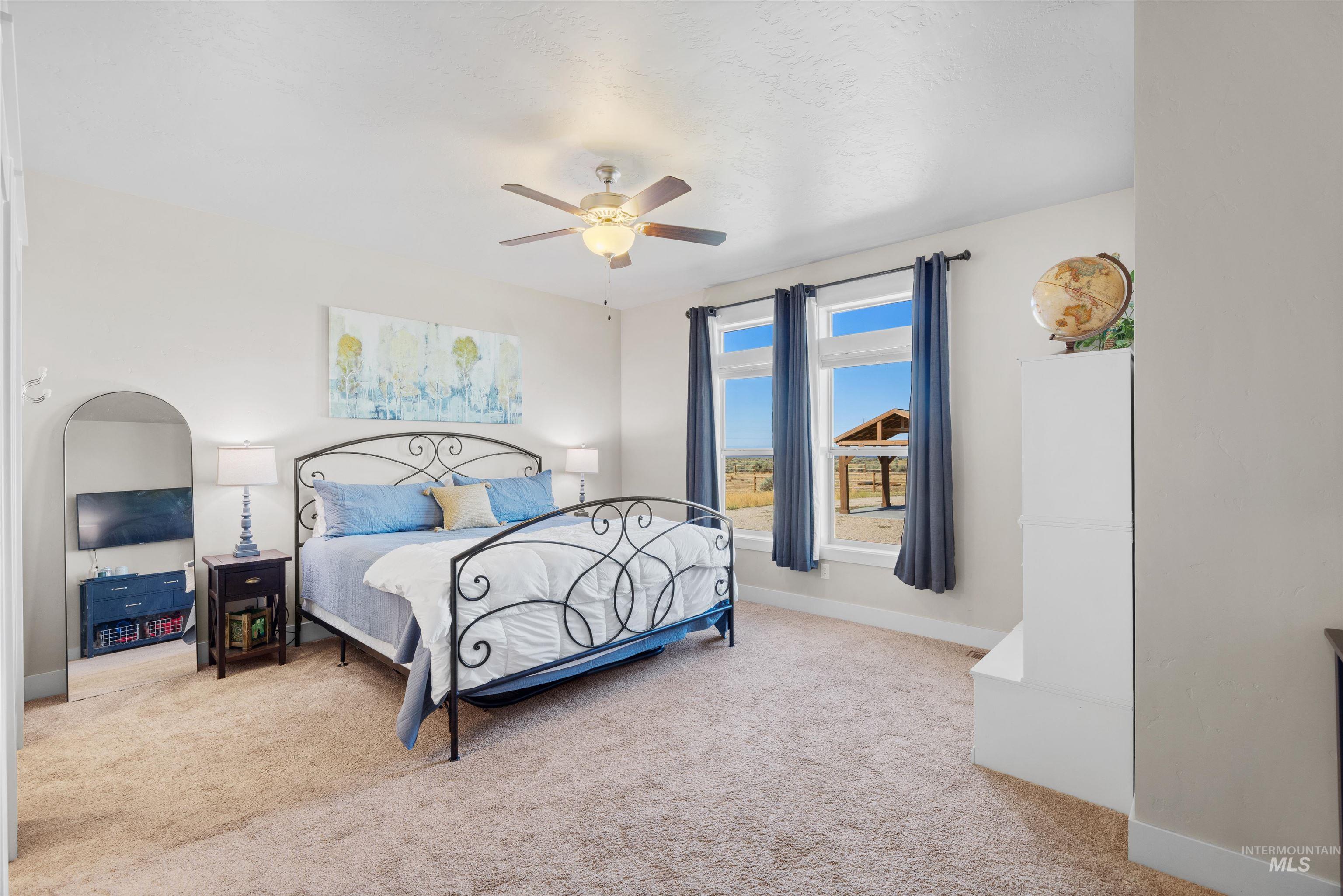 Carpeted bedroom with baseboards and ceiling fan