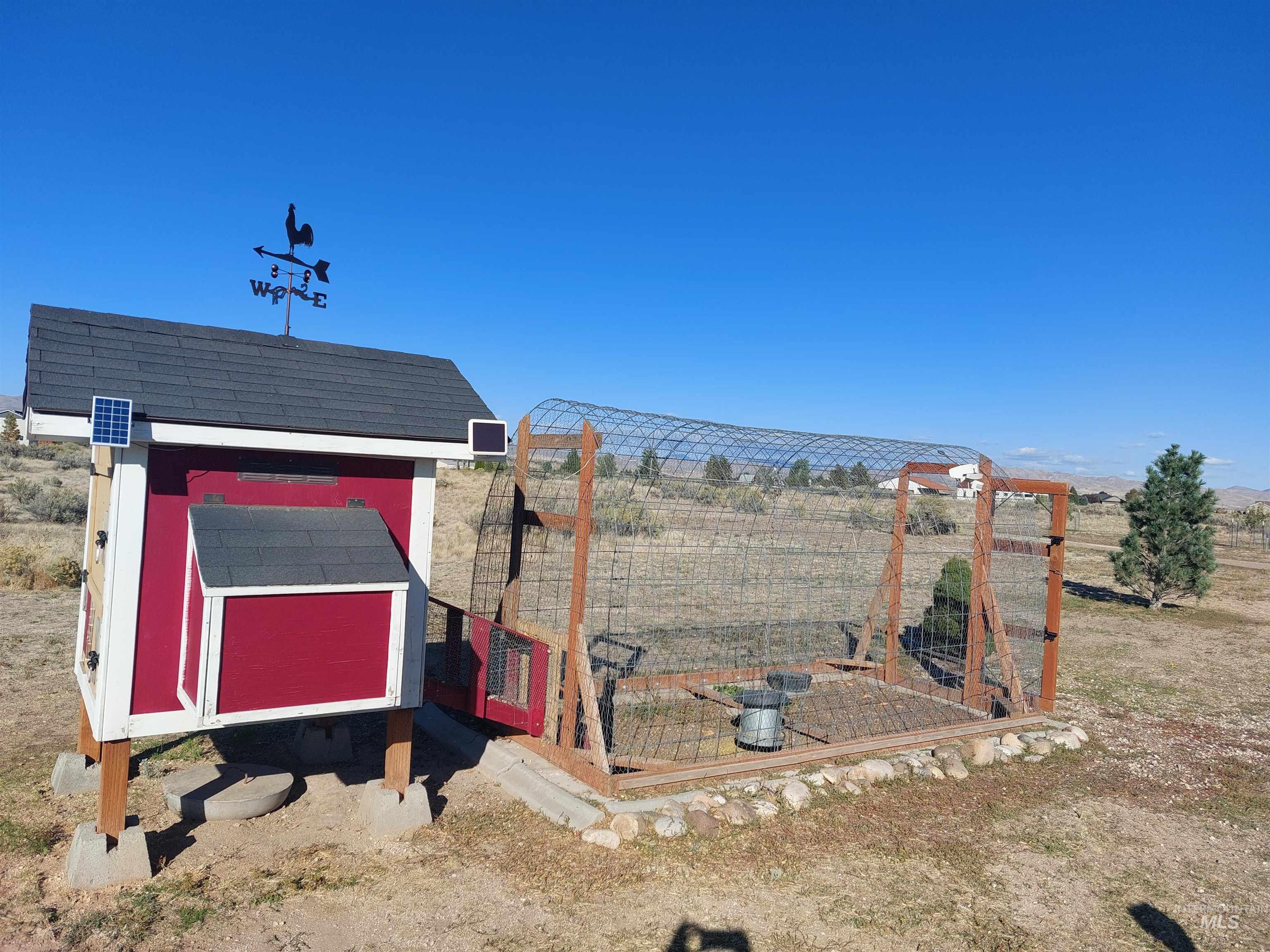 View of yard with exterior structure, an outbuilding, and a rural view