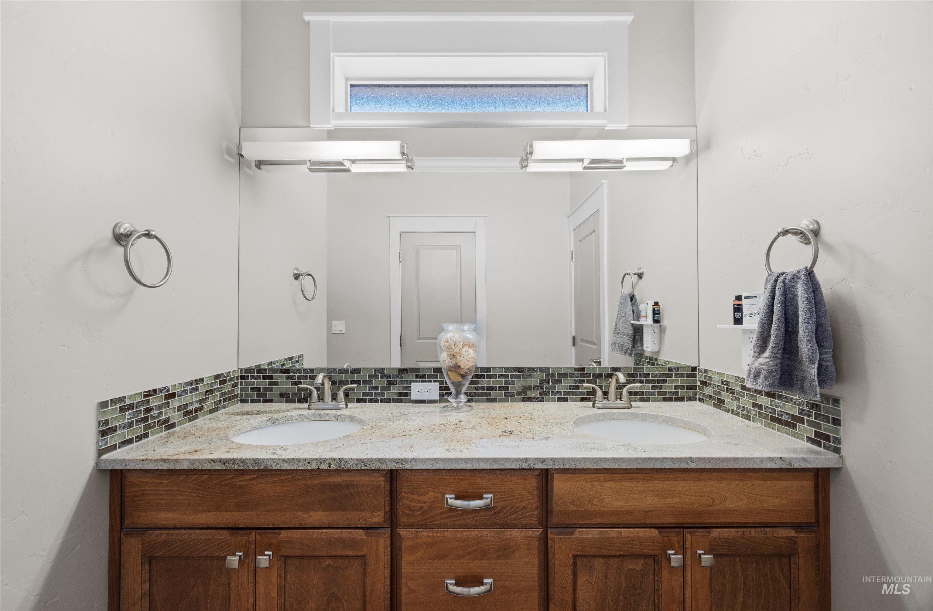 Full bath with decorative backsplash and double vanity