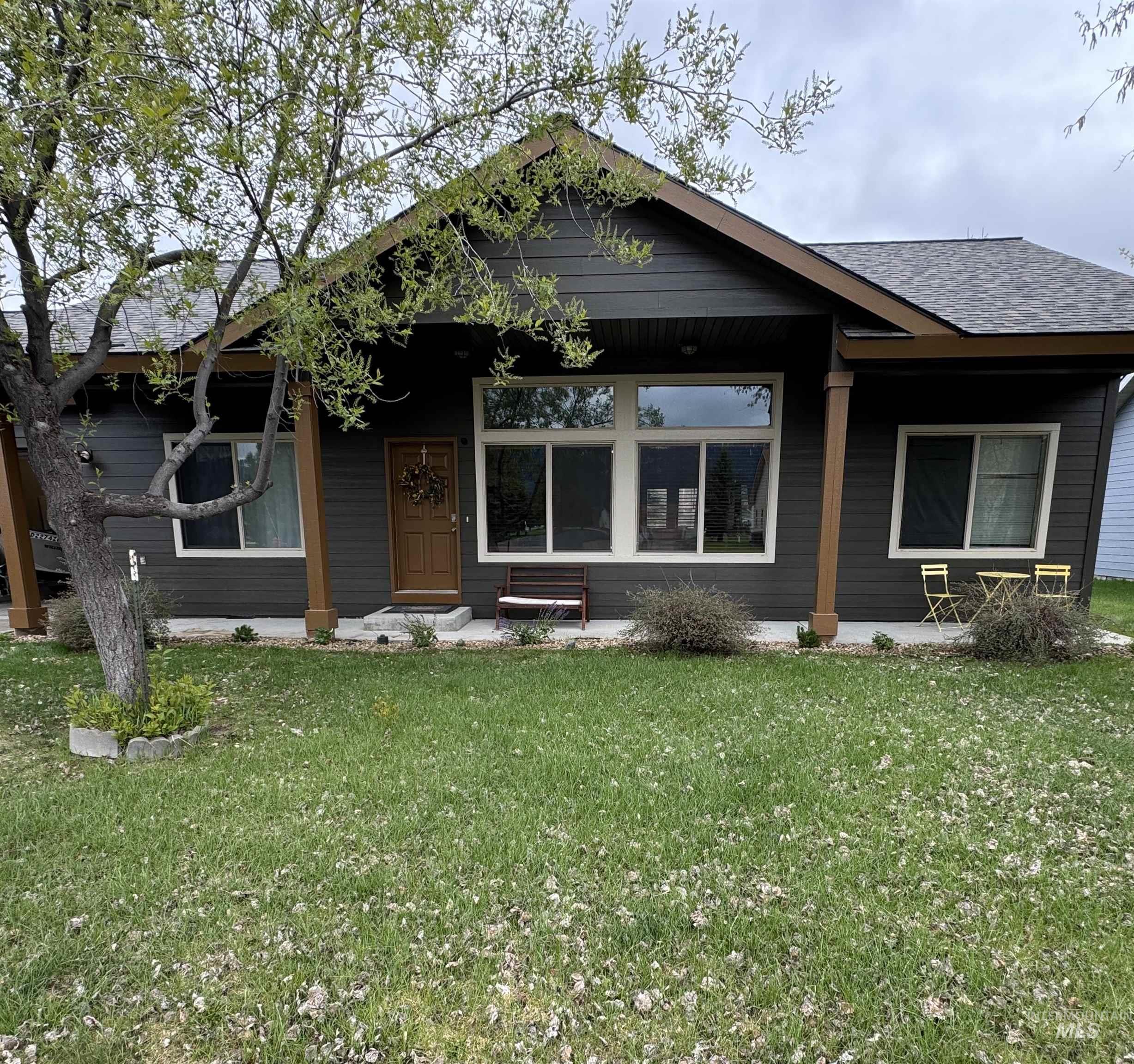 Bungalow with a front lawn, covered porch, and roof with shingles