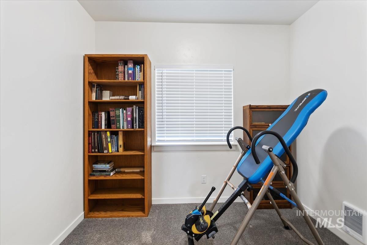 Workout area with baseboards and dark carpet