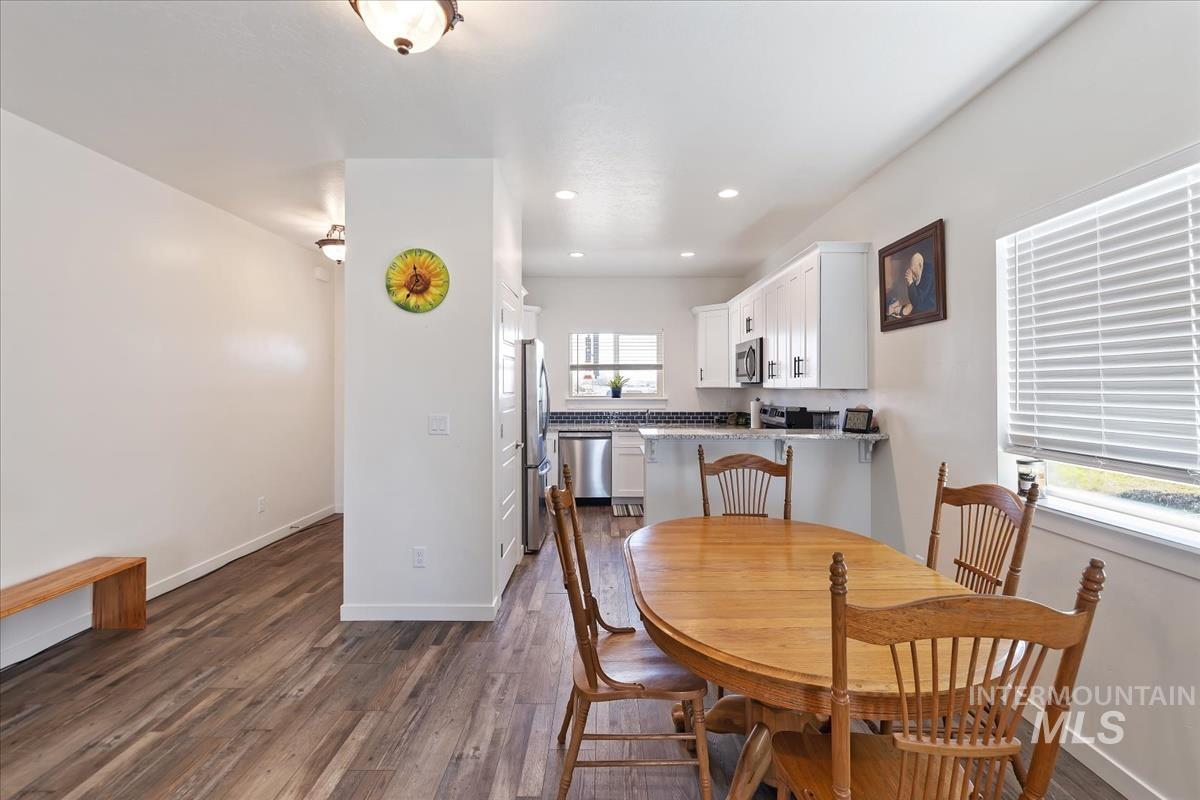 Dining area featuring dark wood-style flooring and recessed lighting