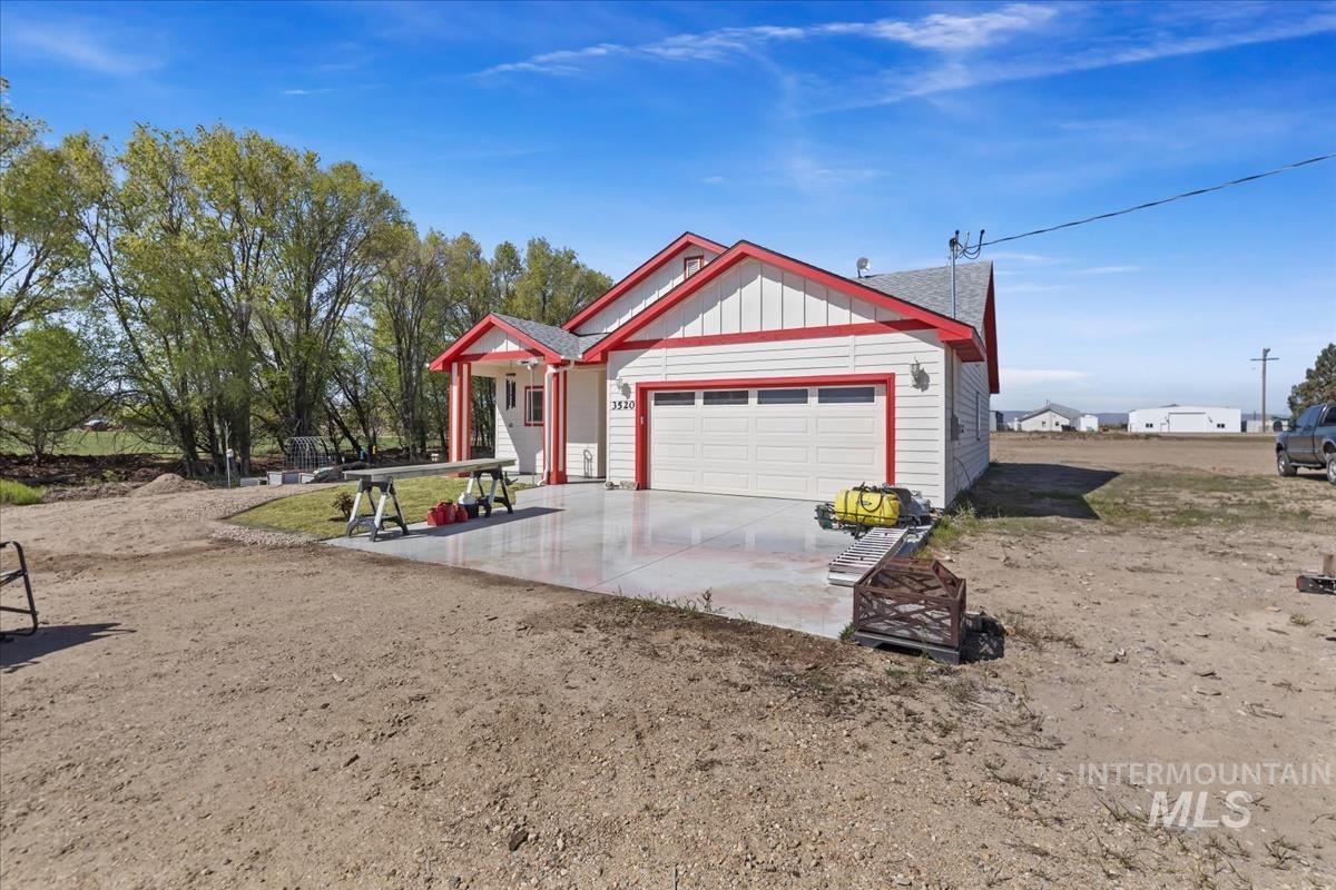 View of front of home with board and batten siding, an attached garage, and driveway