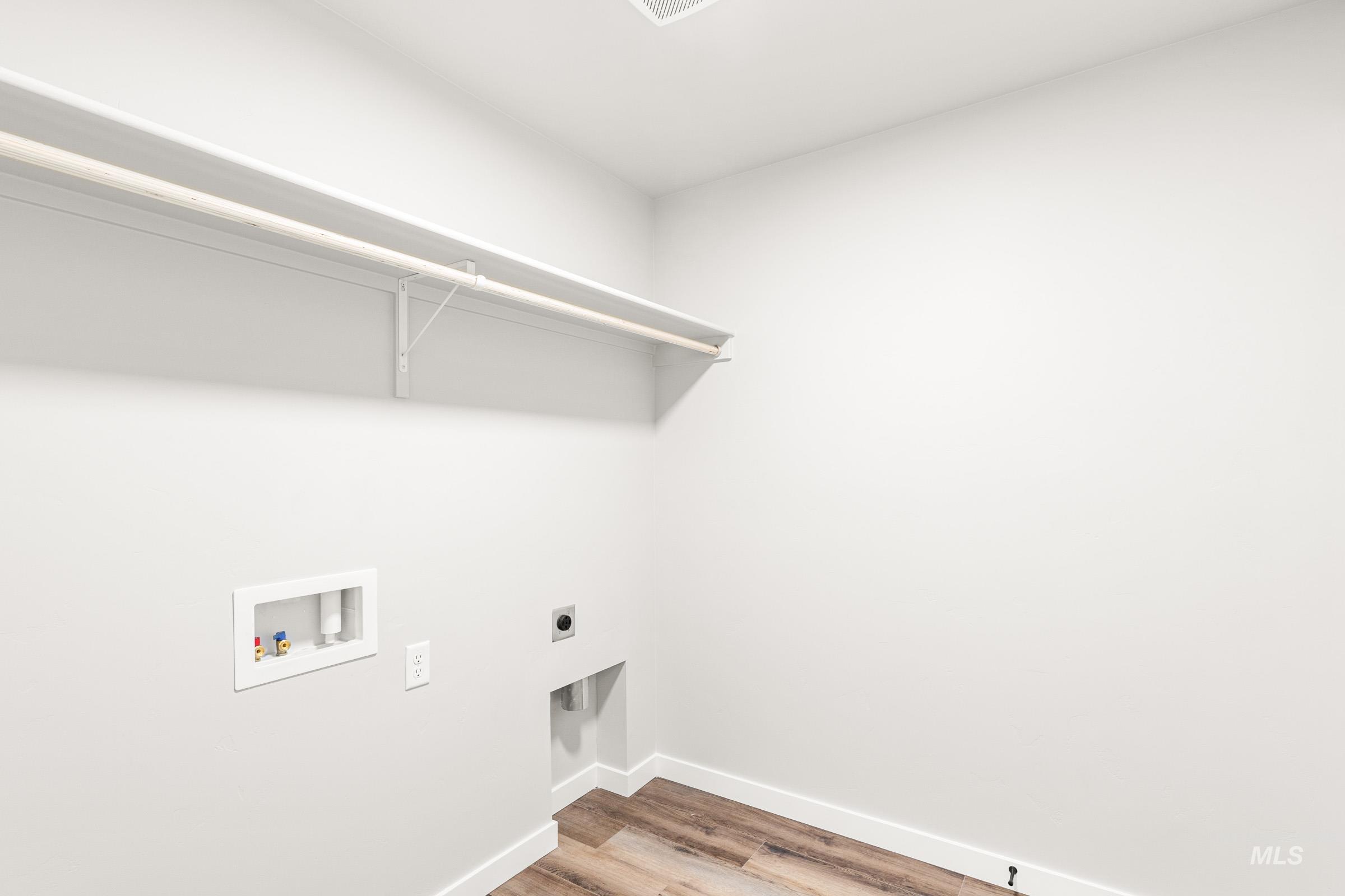 Laundry area featuring light wood-type flooring, electric dryer hookup, and washer hookup