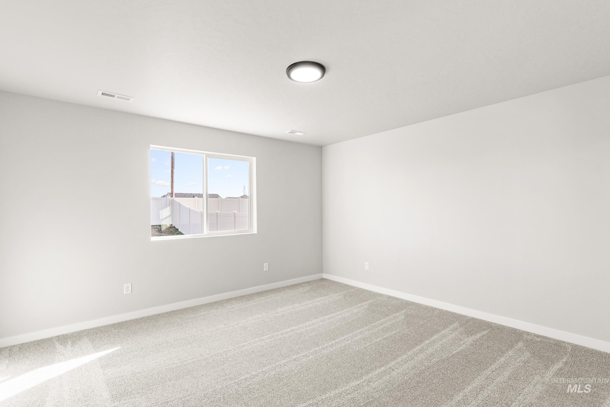 Spare room with carpet and baseboards