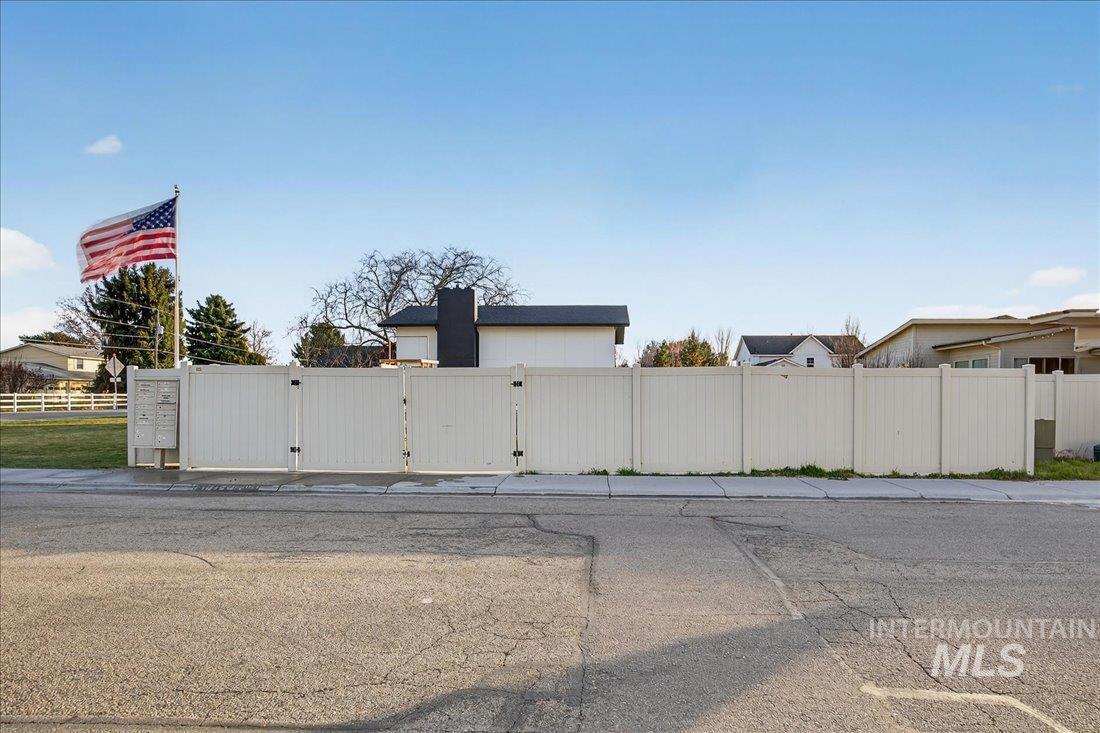 View of asphalt street featuring a gate