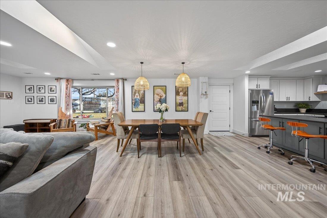 Dining area with recessed lighting and light wood-type flooring