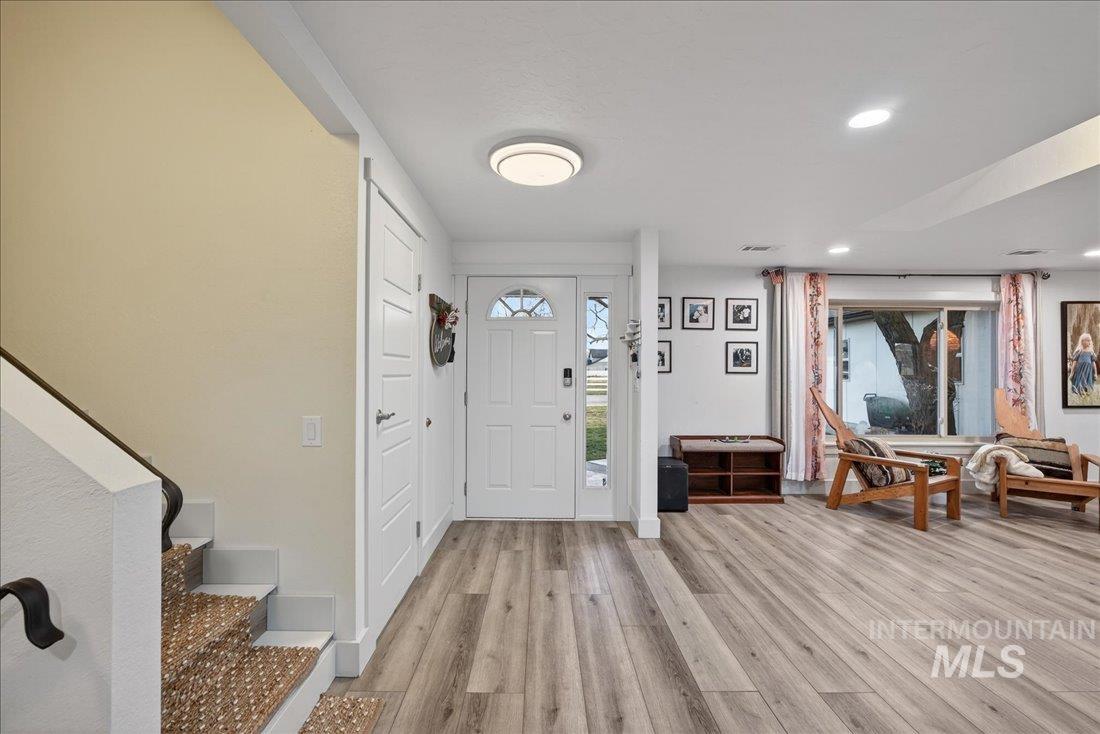Foyer entrance with light wood-type flooring, recessed lighting, and stairs