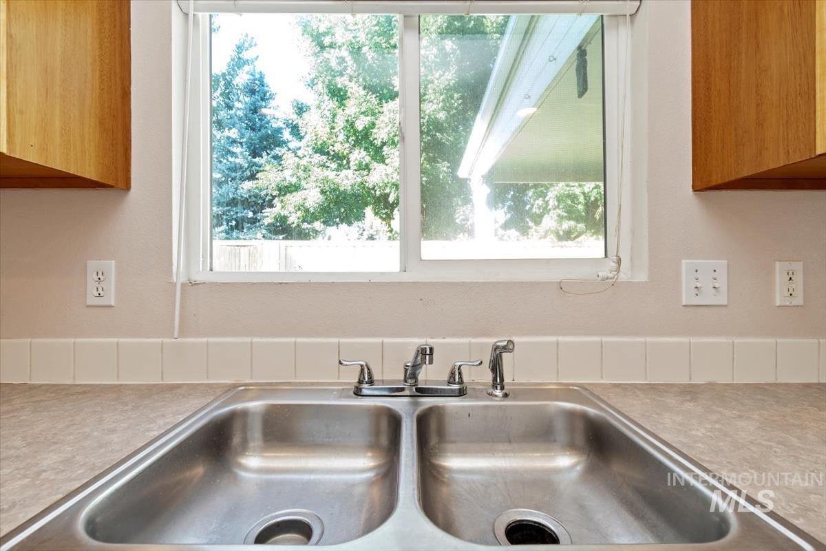 Kitchen view of light countertops and brown cabinetry