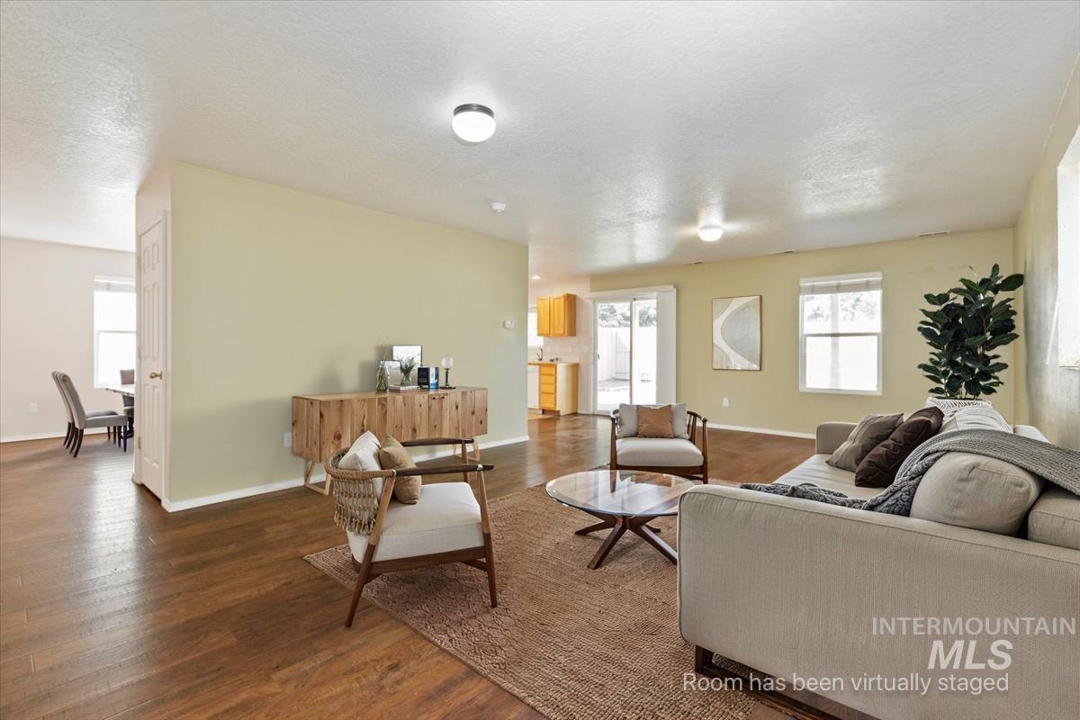 Living area with dark wood-style flooring and a textured ceiling