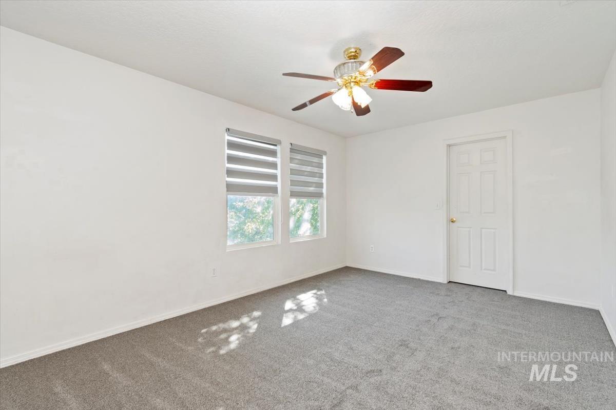 View of front of home featuring an attached garage, driveway, stone siding, and a front lawn