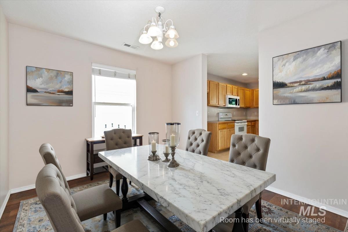 Dining room featuring dark wood-style flooring, a chandelier, and recessed lighting
