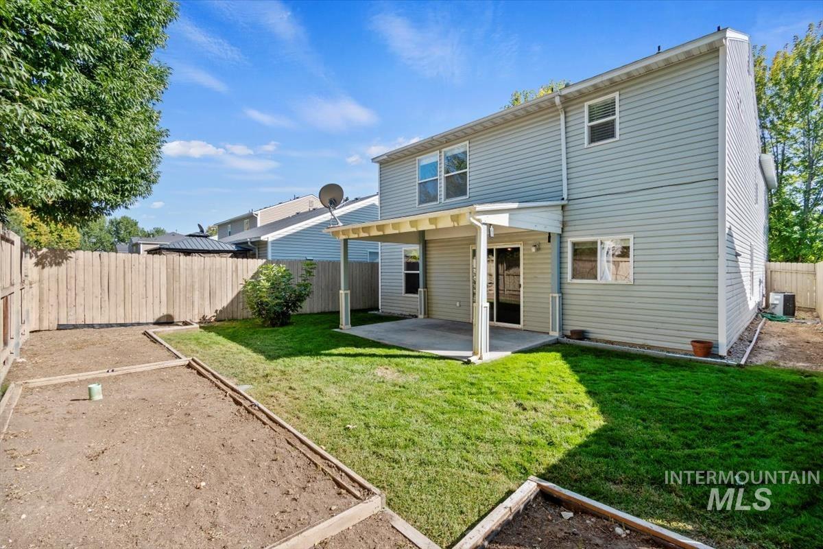 View of front of property featuring a garage, driveway, stone siding, and a front yard