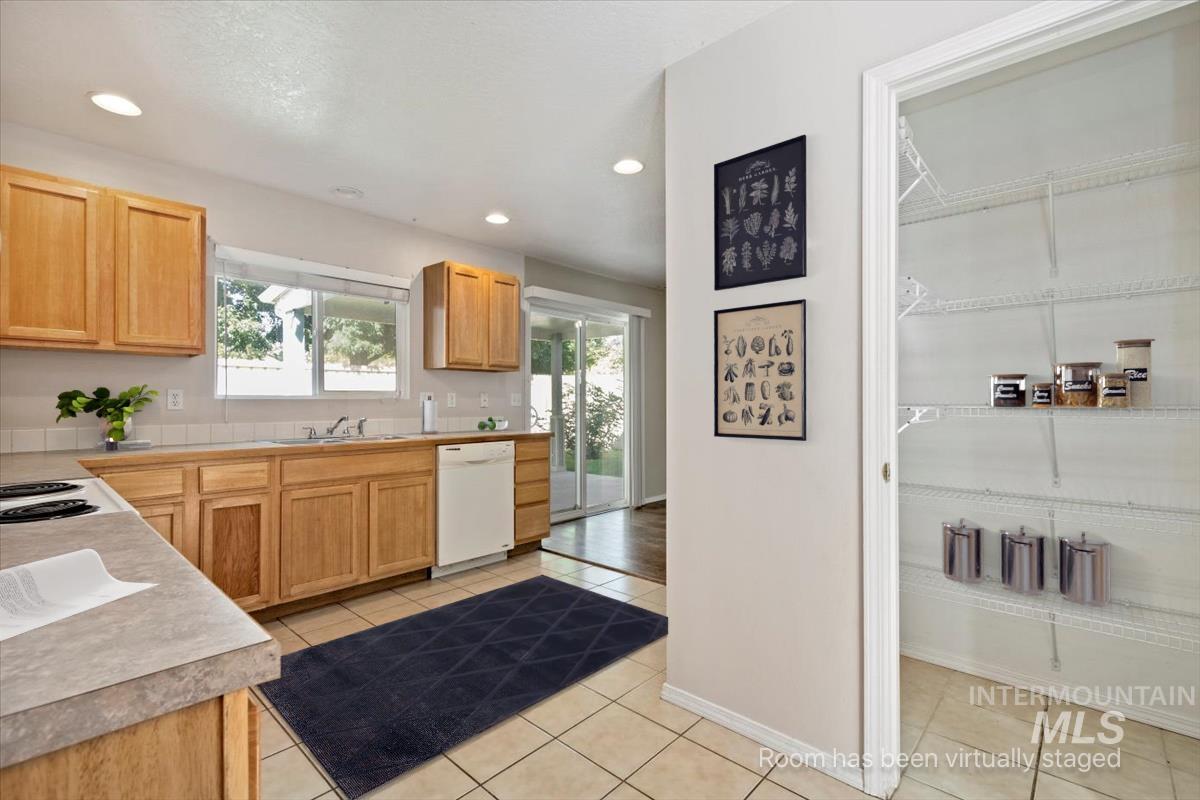 Kitchen featuring light countertops, recessed lighting, white dishwasher, light brown cabinetry, and light tile patterned flooring