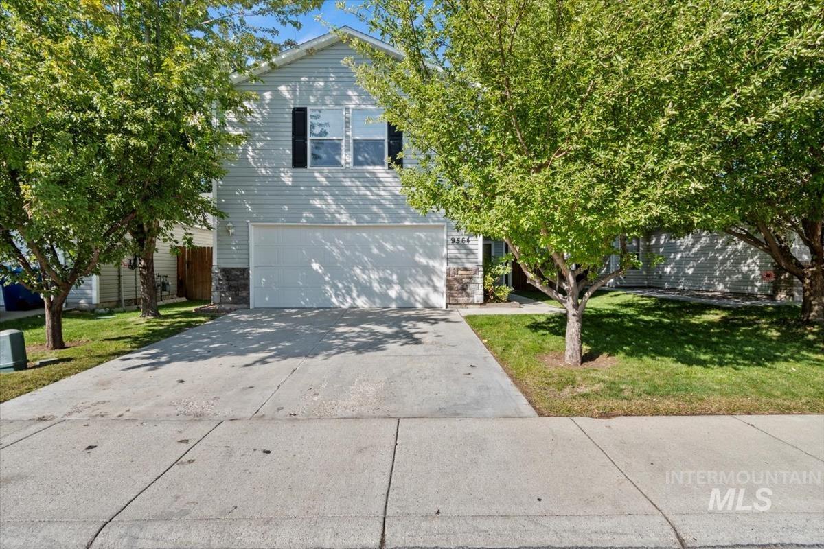 View of front of property with driveway, a front lawn, a garage, and stone siding