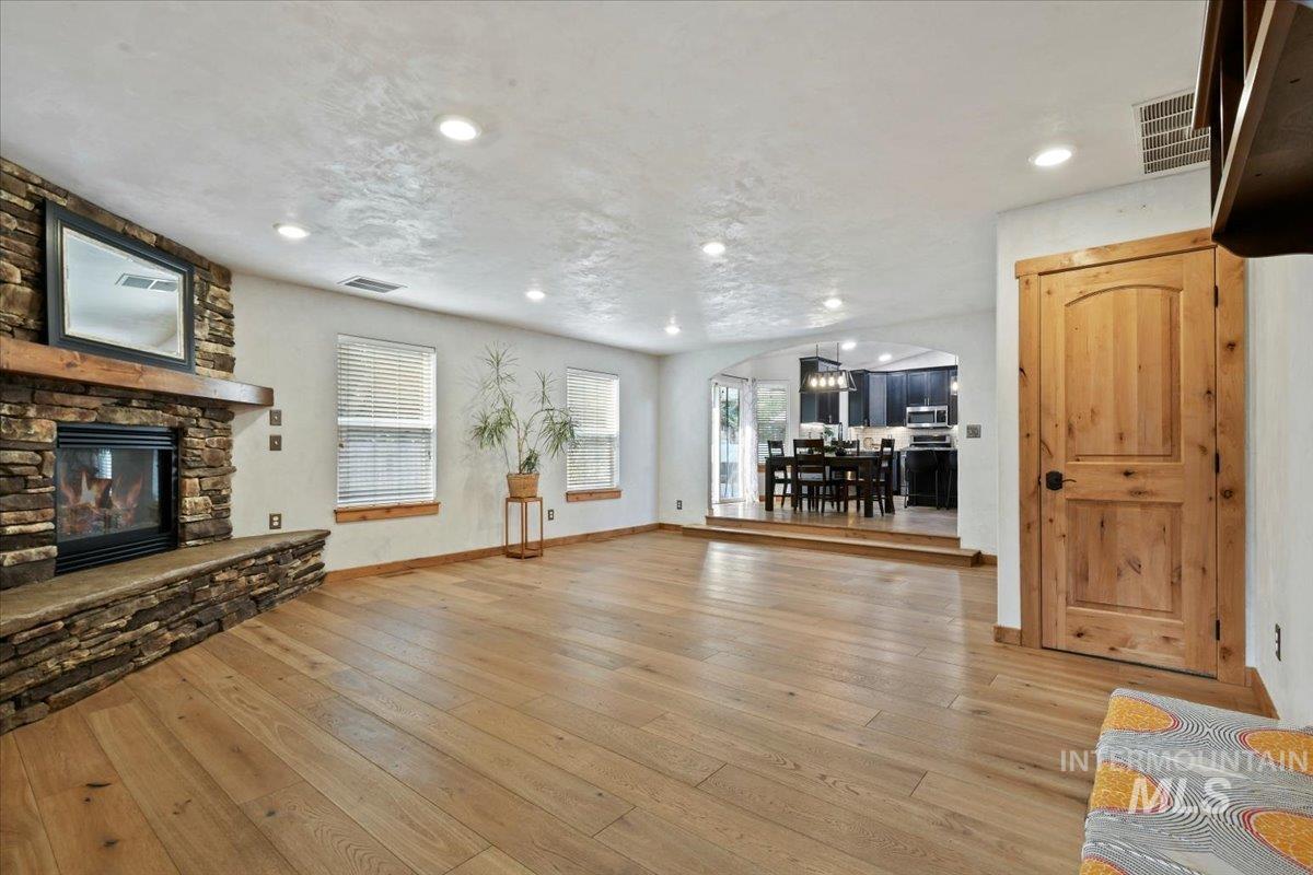 Step down into the spacious great room with beautiful hardwood flooring and stone gas fireplace