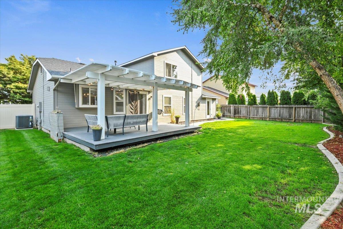 Rear view of property with a fenced backyard, a Trek deck and pergola