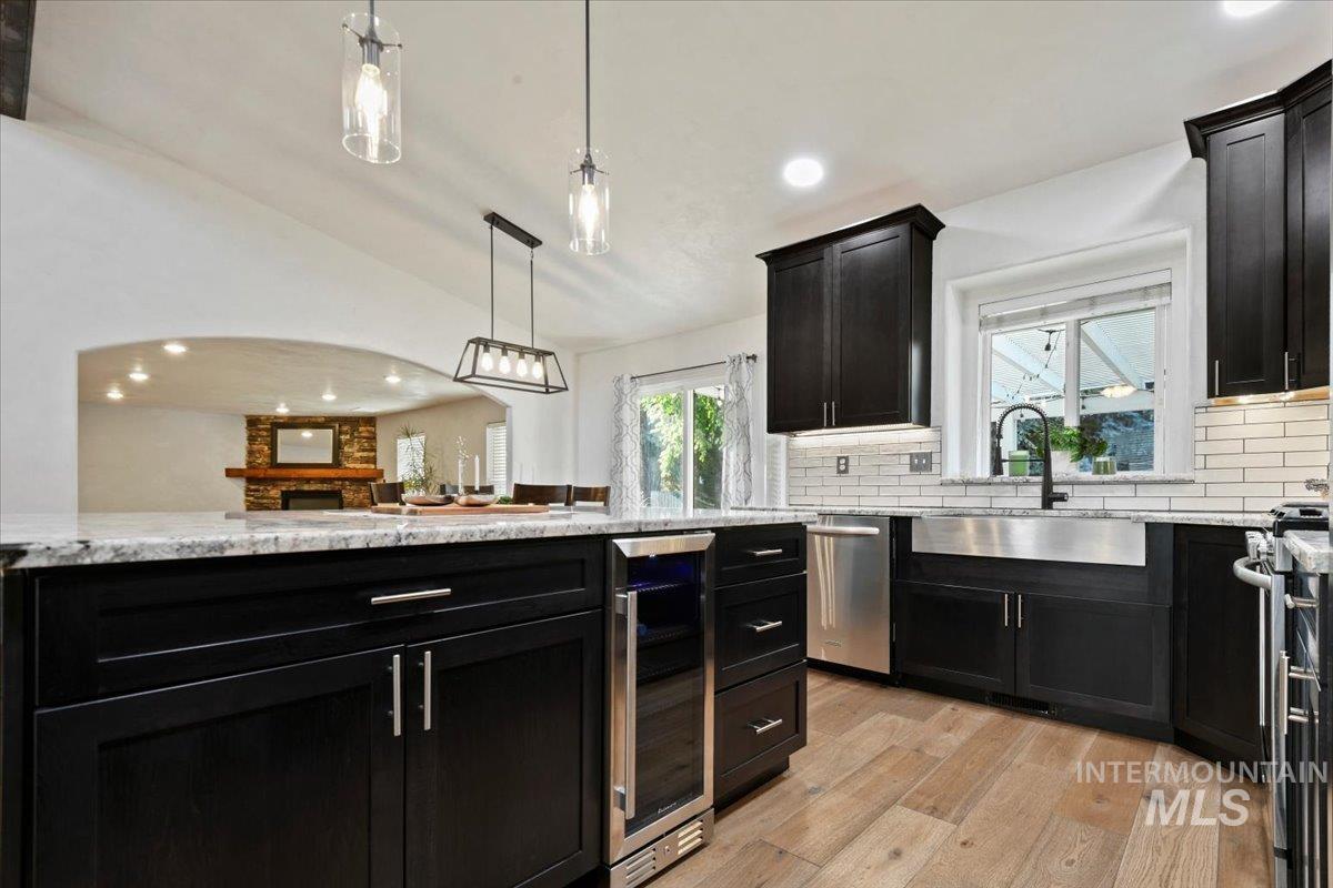 Showcasing a beverage refrigerator, gas cooking and undermounted lighting