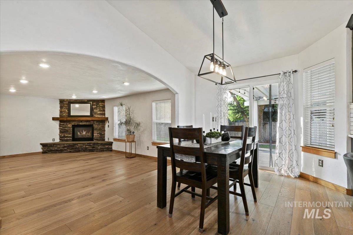 Dining room featuring arched walkways, light hardwood flooring, natural light overlooking the great room